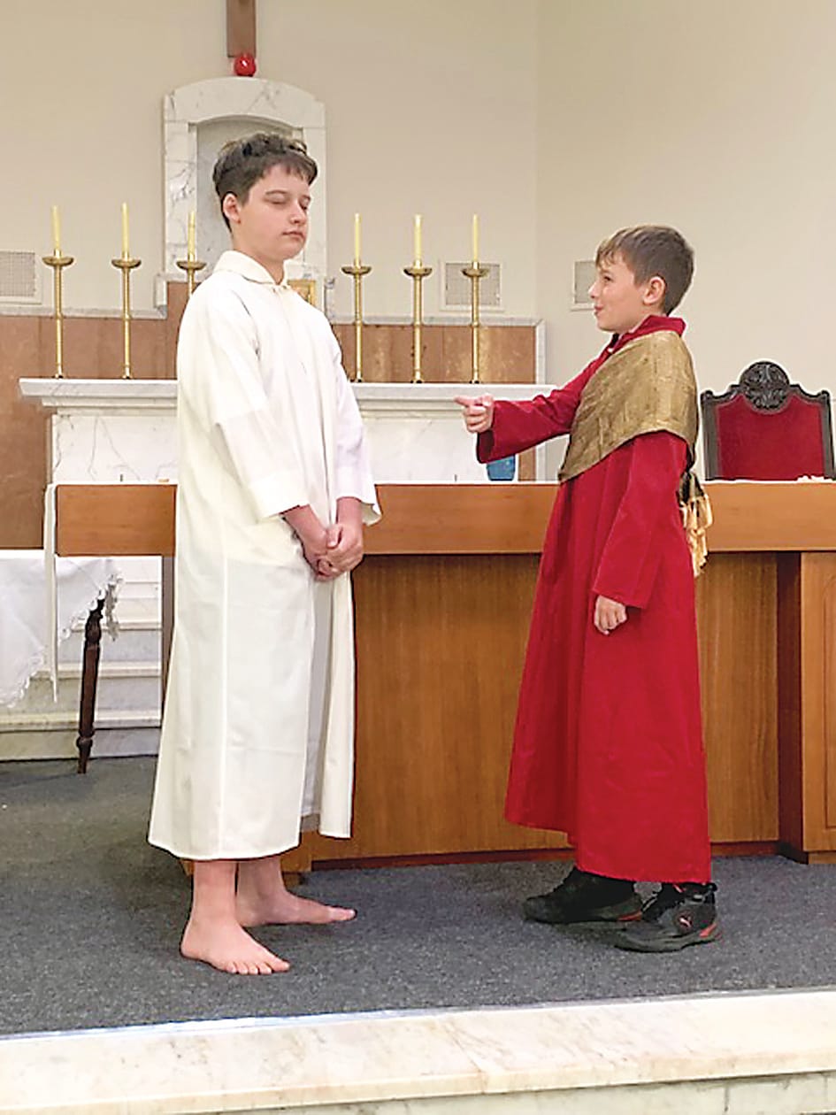 Above: The soldiers played by Owen (left) and Asher (right) put Jesus played by Tom on the cross.Left:Tom as Jesus and Ethan as Pilate during The Easter Story presentation.