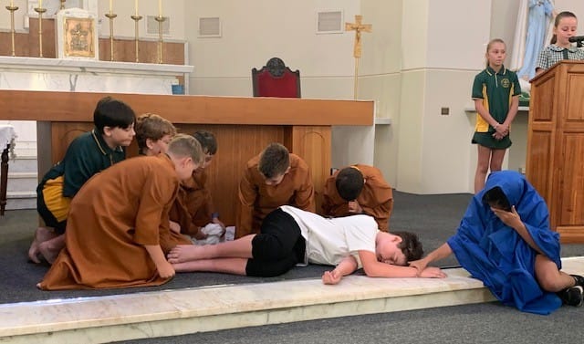 The soldiers acted by Beau, Connor, Charlie, Kieran, Billy and Conrad took Jesus acted by Tom down and Mary his mother, acted by Maycee, was with him.