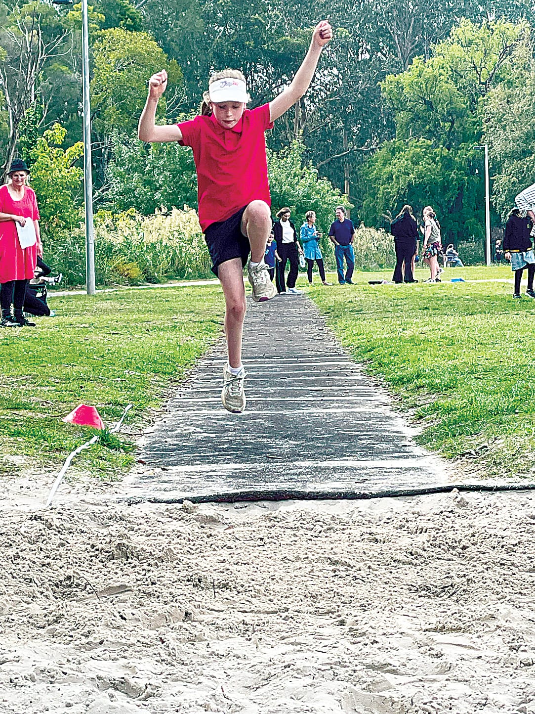 Evie from Neerim District Rural Primary School hops, skips and jumps her way into the triple jump pit.
