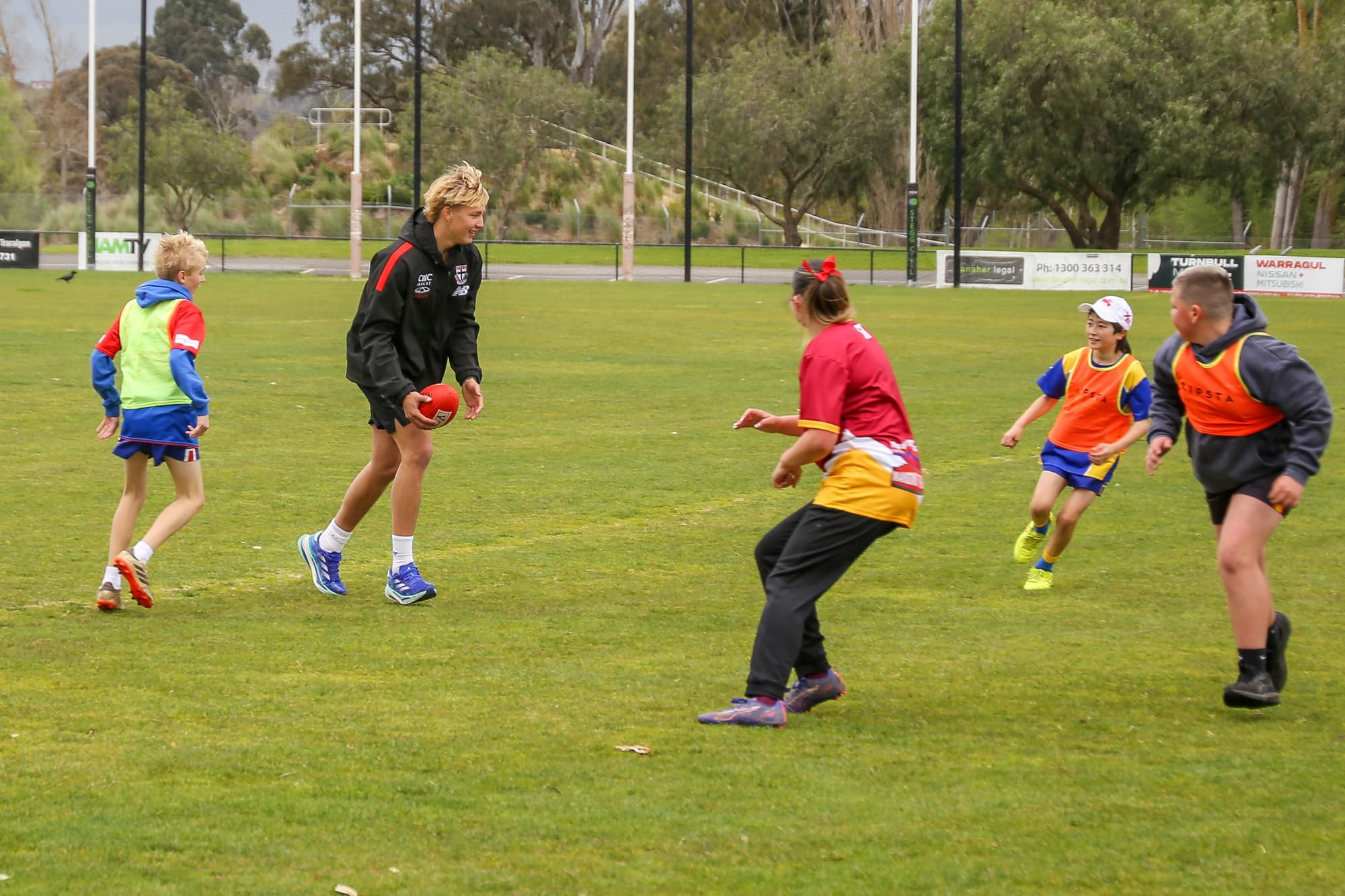 Alix Tauru poses with Izzy Vouden, who is wearing his debut AFL guernsey after correctly guessing which jumper it was.