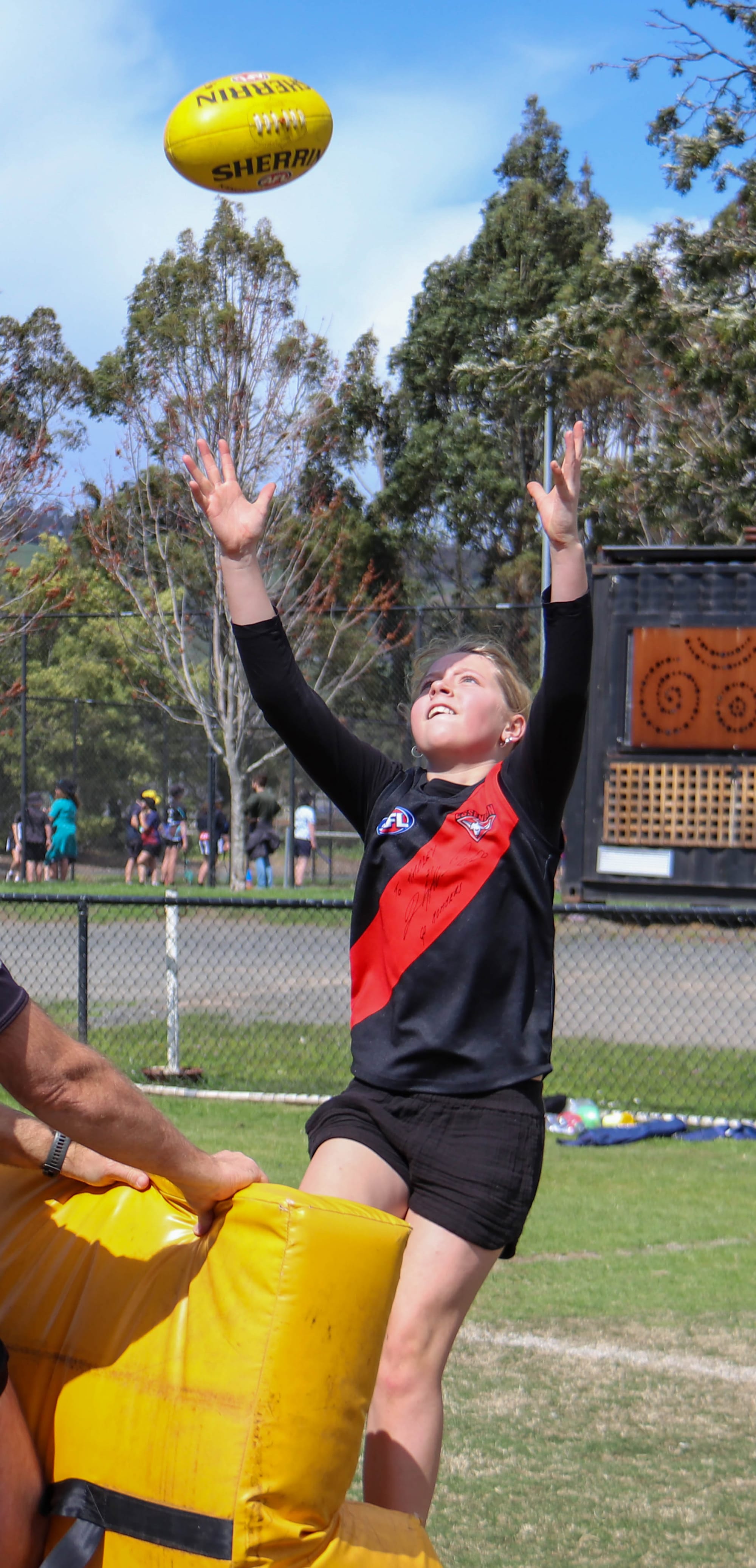Essendon fan Hadley Roberts emulates her heroes as she goes for a mark.