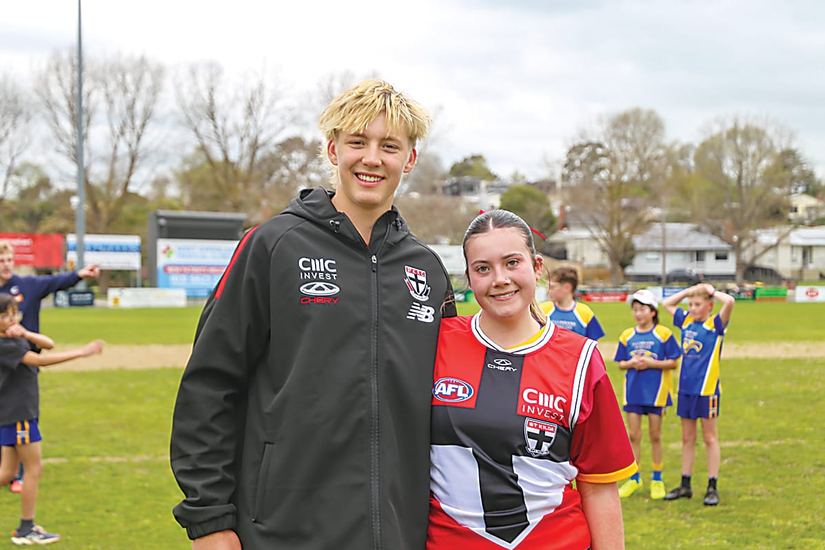 Alix Tauru poses with Izzy Vouden, who is wearing his debut AFL guernsey after correctly guessing which jumper it was.