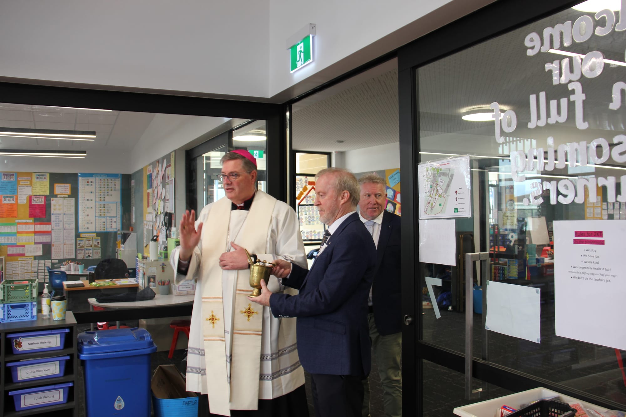 Bishop of Sale Greg Bennet blesses a new classroom at St Ita's Catholic Primary School in Drouin alongside Father Brendan Hogan and principal Andrew Osler.