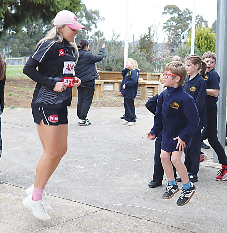 Collingwood's Mikayla Hyde joins Ellinbank Primary School's Lenny Conroy in a skipping contest.