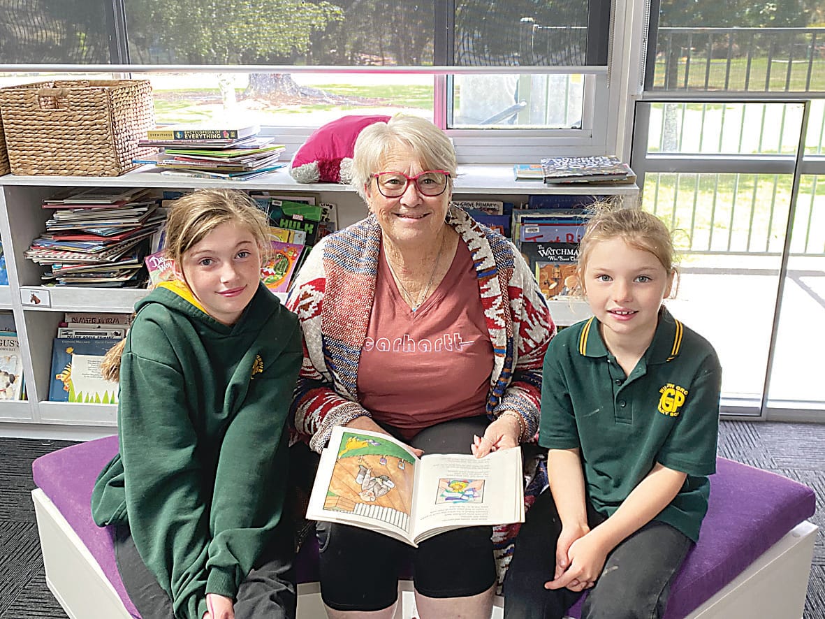 Sidney and Quinn read a book with their grandmother Jennifer.