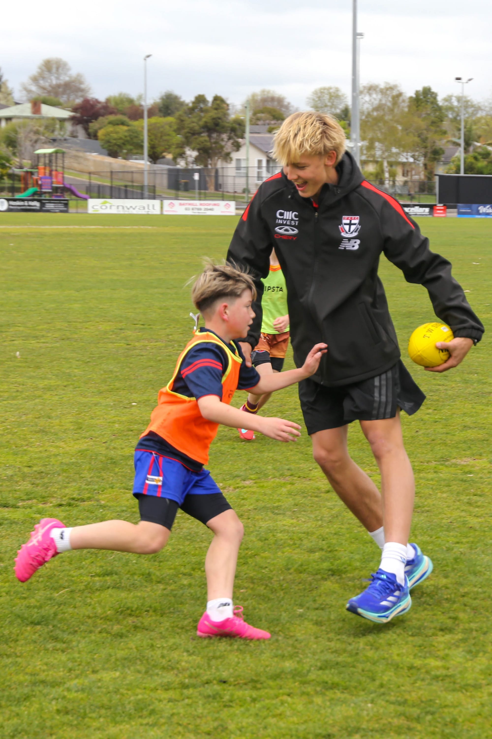 Alix Tauru poses with Izzy Vouden, who is wearing his debut AFL guernsey after correctly guessing which jumper it was.