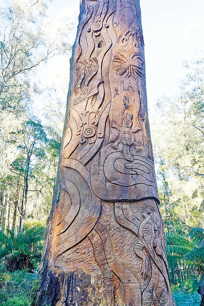 Sculptor Paul Stafford and Kurnai elder Dr Eileen Harrison at the carved 7.5 metre artwork in Toorongo Falls Reserve.