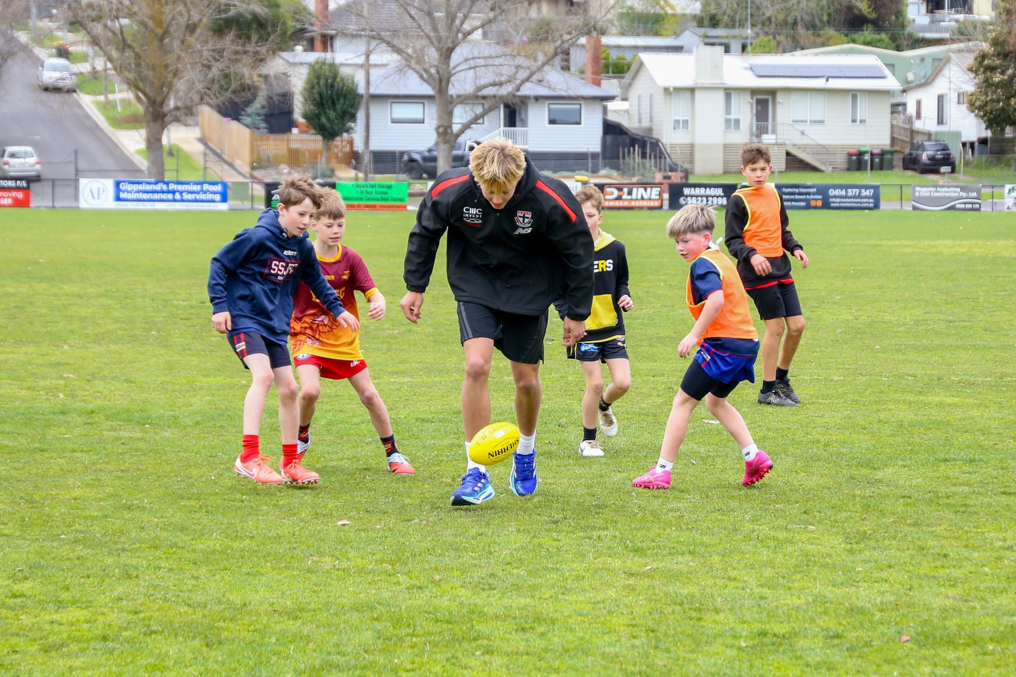 Alix Tauru poses with Izzy Vouden, who is wearing his debut AFL guernsey after correctly guessing which jumper it was.