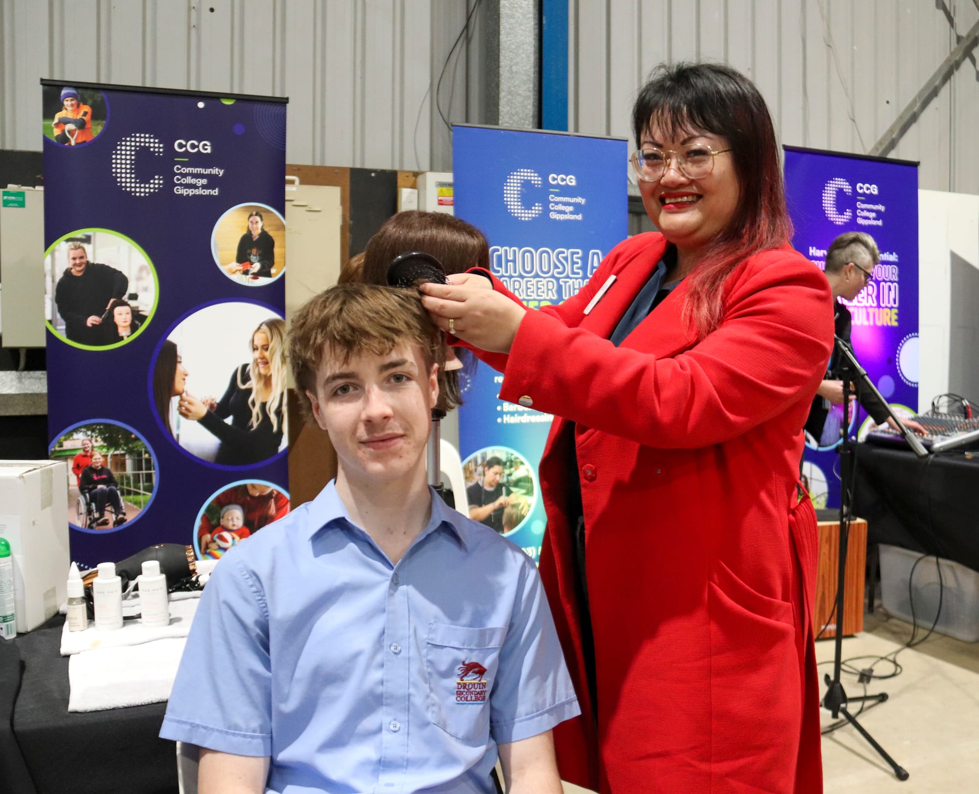 Drouin Secondary College student Adrian Hays has his hair done by CCG's Den Lim