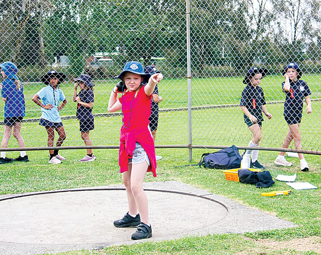 Neerim South Primary School student Gracie points in the direction she wants her shot put to travel.