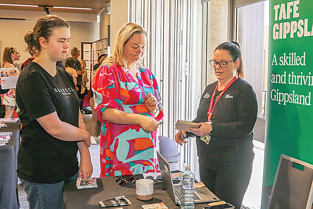 Right: Kiara and Rebecca Possamai discuss what TAFE Gippsland has to offer with Tammy Borg.Below: Cooking up a sausage sizzle at the expo are members of the Drouin Men's Shed, Dennis Auld, Michael Garvey, Chris Green, Steve Bone and Peter Broughan.
