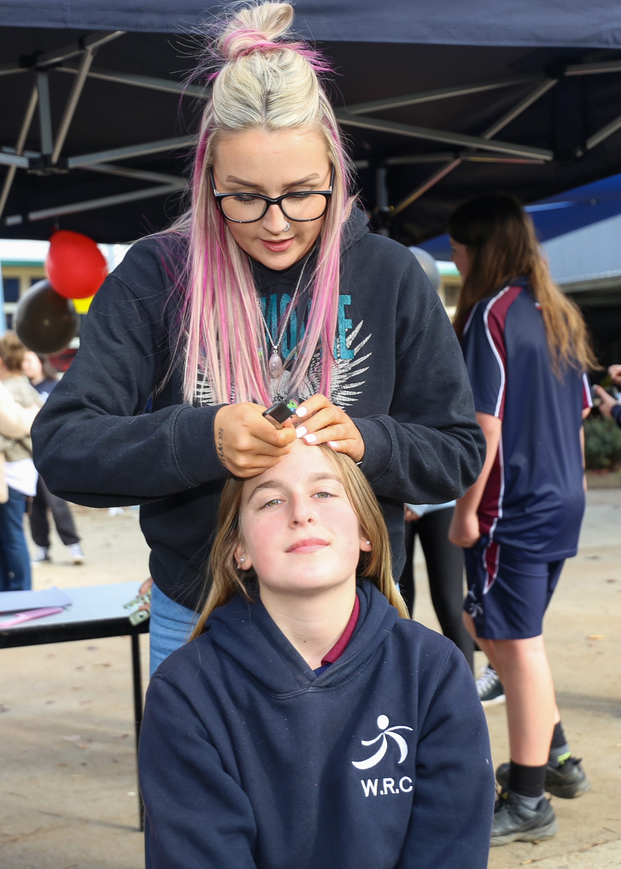 Asha Wilkins-Kaighin prepares to face paint Summer Hancock.