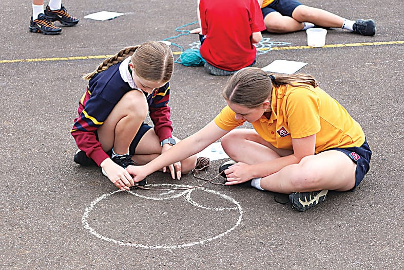 Charlotte McKenna and Anneke Beamish using string to construct their mandala.
