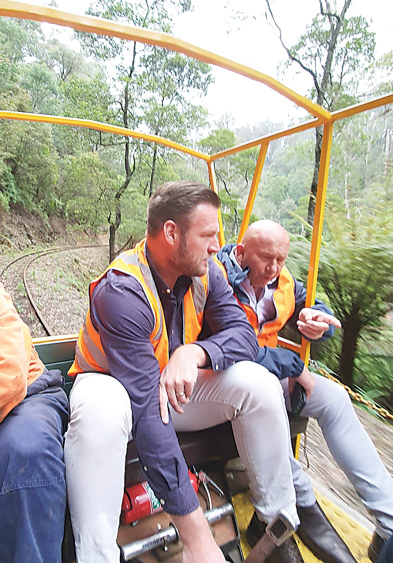 State shadow minister for tourism Sam Groth at the controls of a rail trolley and Member for Narracan Wayne Farnham holding on firmly during a visit to discuss plans for extension of the Walhalla Goldfield Railway.