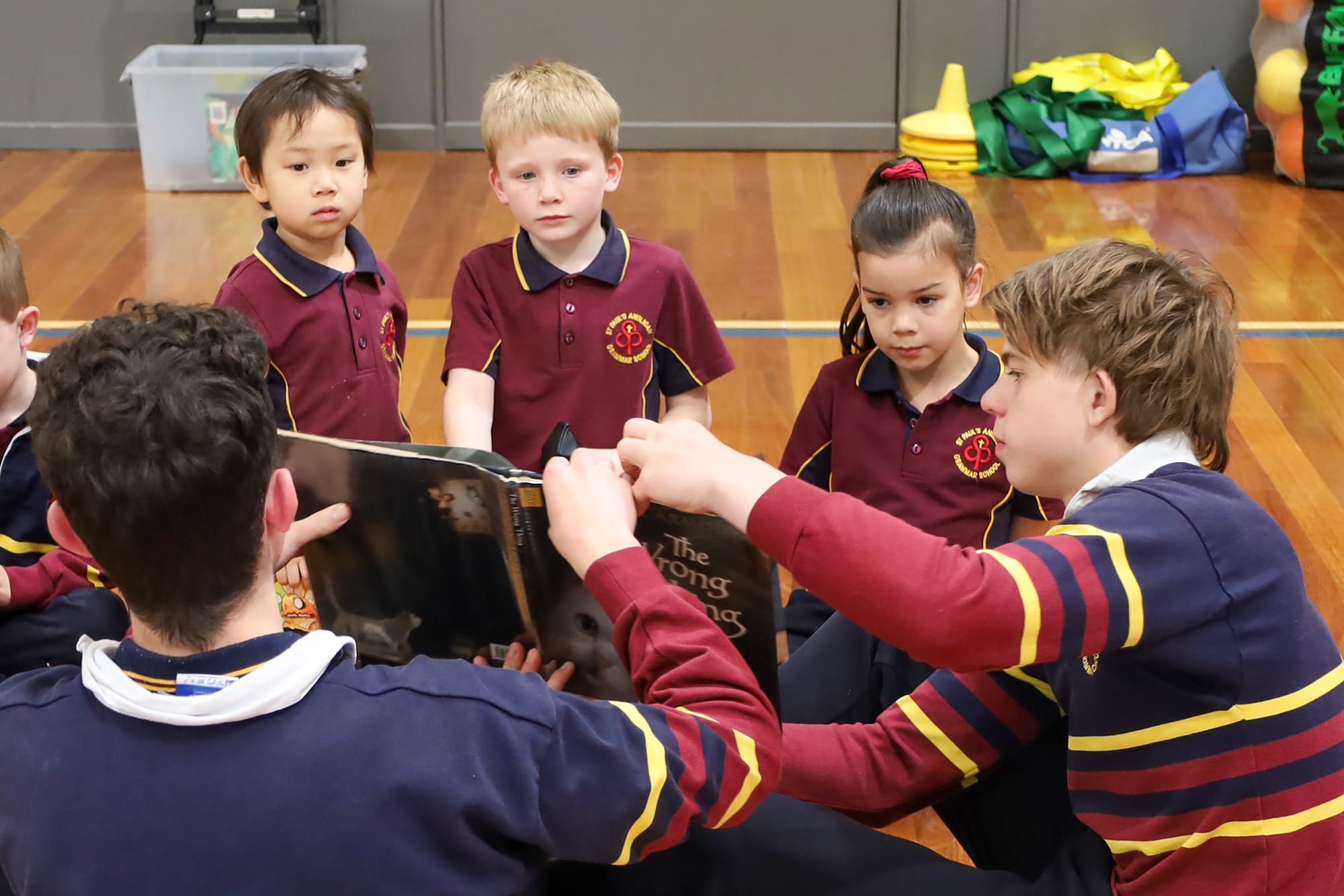 Year 10 students Ayden Clarke and Joel Armstrong read to Cecilia Su, Ned Parke and Kaia Brewer.