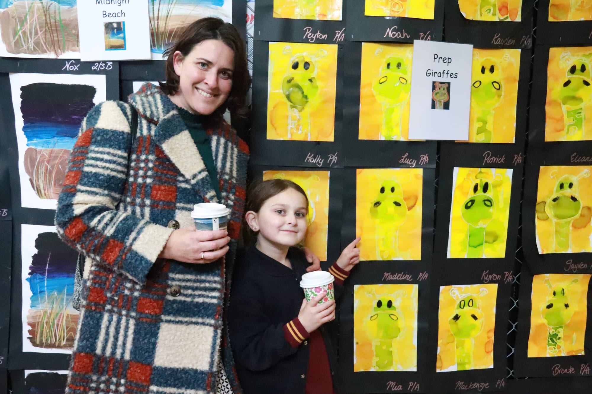 Nina Revill took Madeline Jashar stopped by the coffee van to beat the cold whilst browsing hundreds of artworks on display at Drouin West Primary School. Madeline points to one of her art pieces depicting a giraffe.