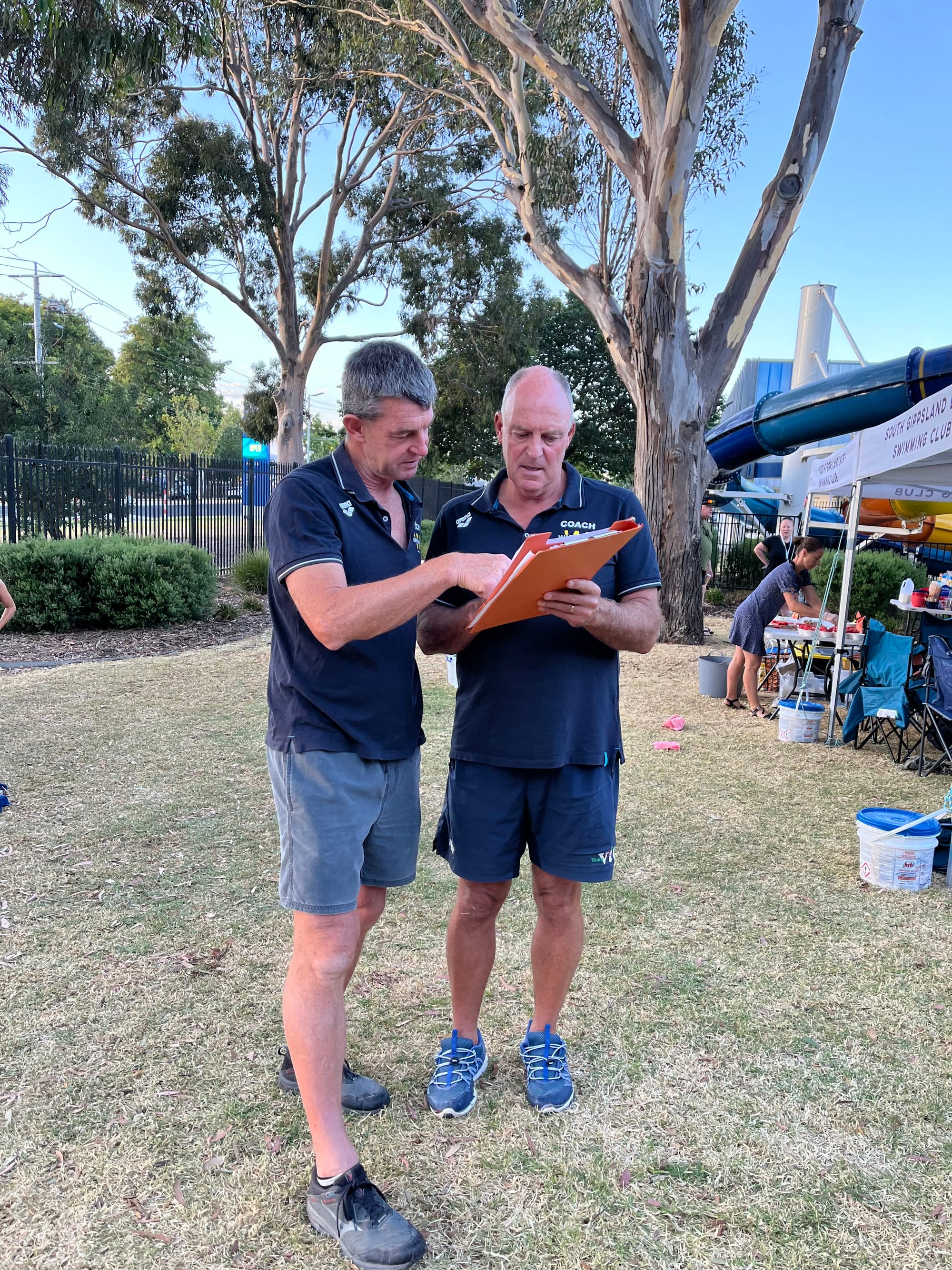Coaches Paul Myers and Andrew Marks talk relay strategy.