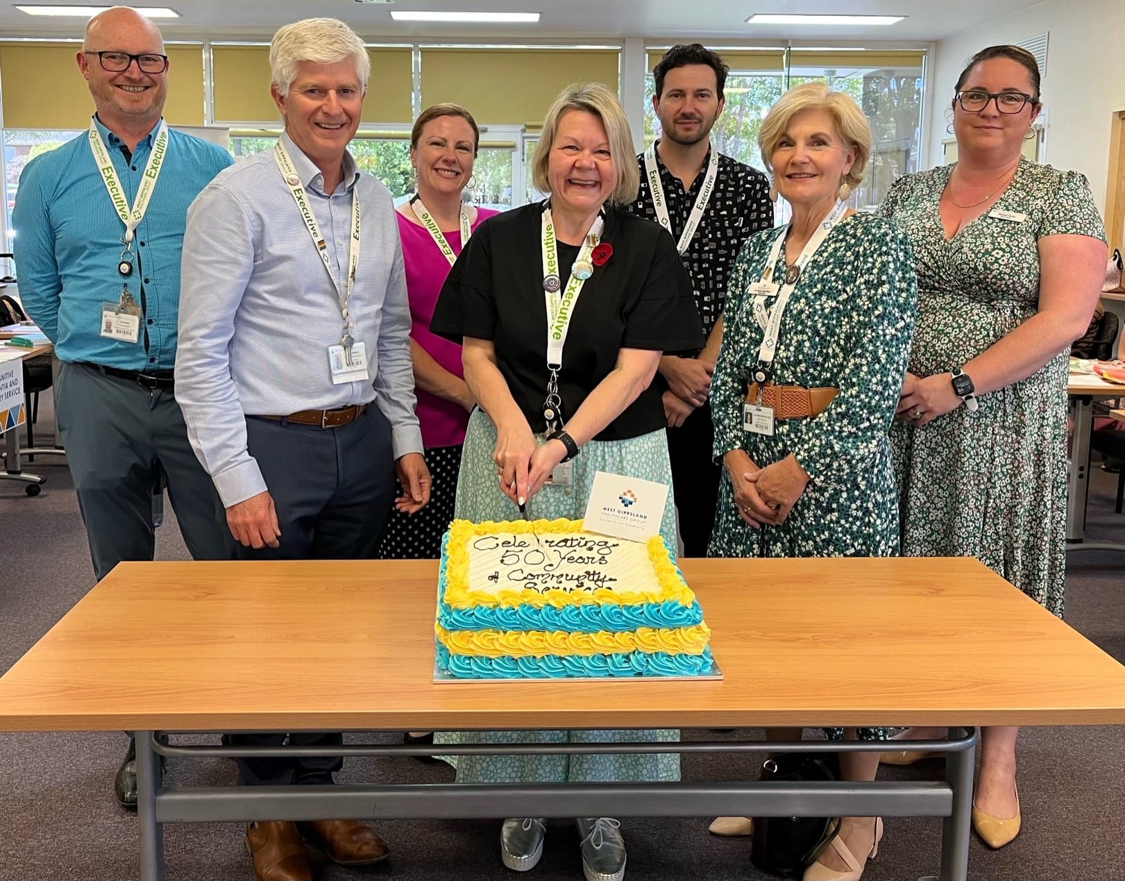 Gathering to cut a cake celebrating 50 years of community health services in Victoria day are (from left) West Gippsland Healthcare Group's acting director of people and culture Richard Adams, chief executive officer Dan Weeks, director of clinical operations Trish O'Kelly, director of allied and community health Audra Fenton, director of corporate services Justin Walsh, board chair Jo-Anne Moorfoot and board director Shannon Davies.