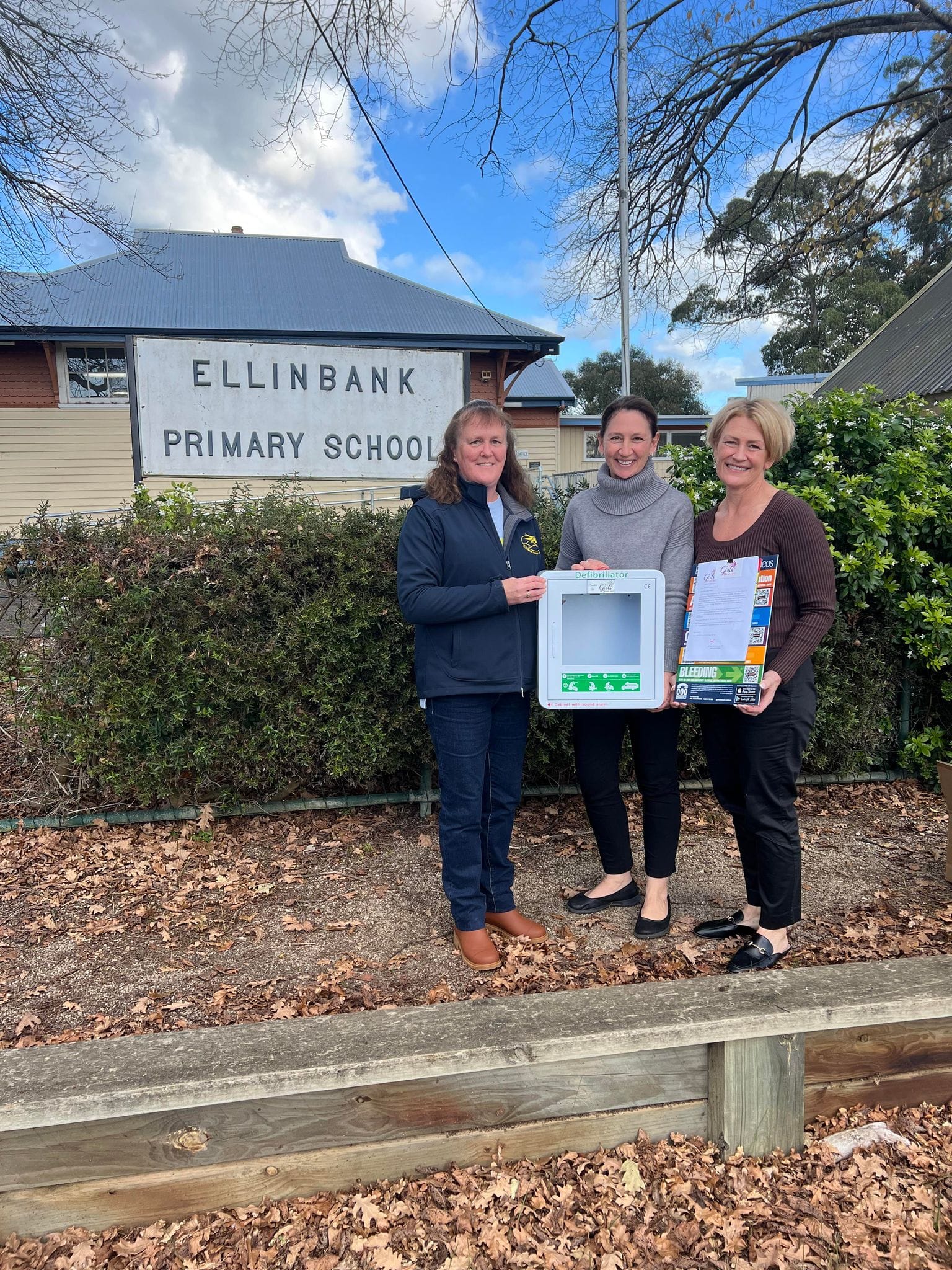 Ellinbank Primary School principal Catherine Clerks receives a defibrillator from A Girls' Day Out committee members Angela Kriesl and Jeanette Radford.