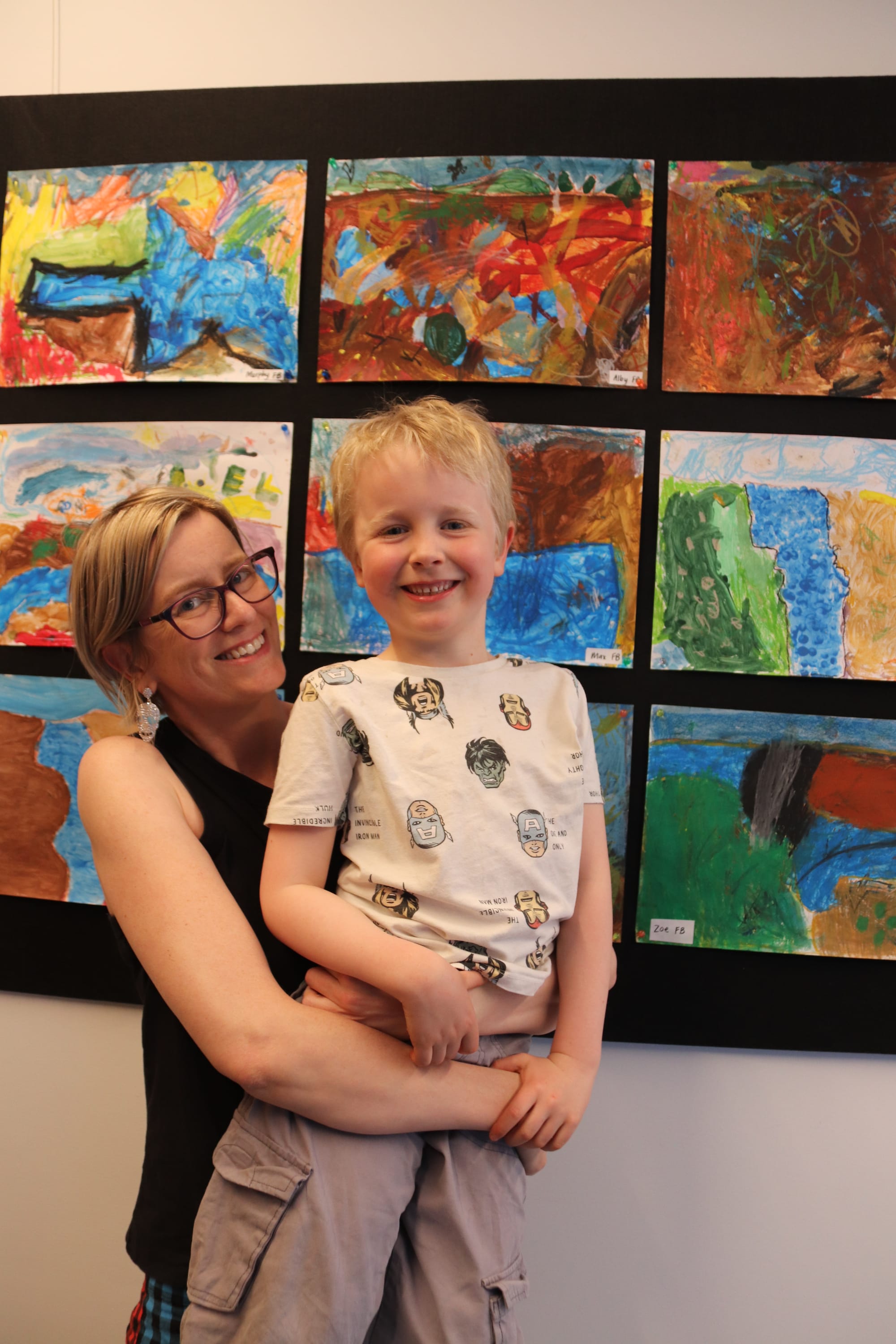 Foundation student Alby Evans gets a big lift from his mum Cassandra Howden so he can point out his work to her.