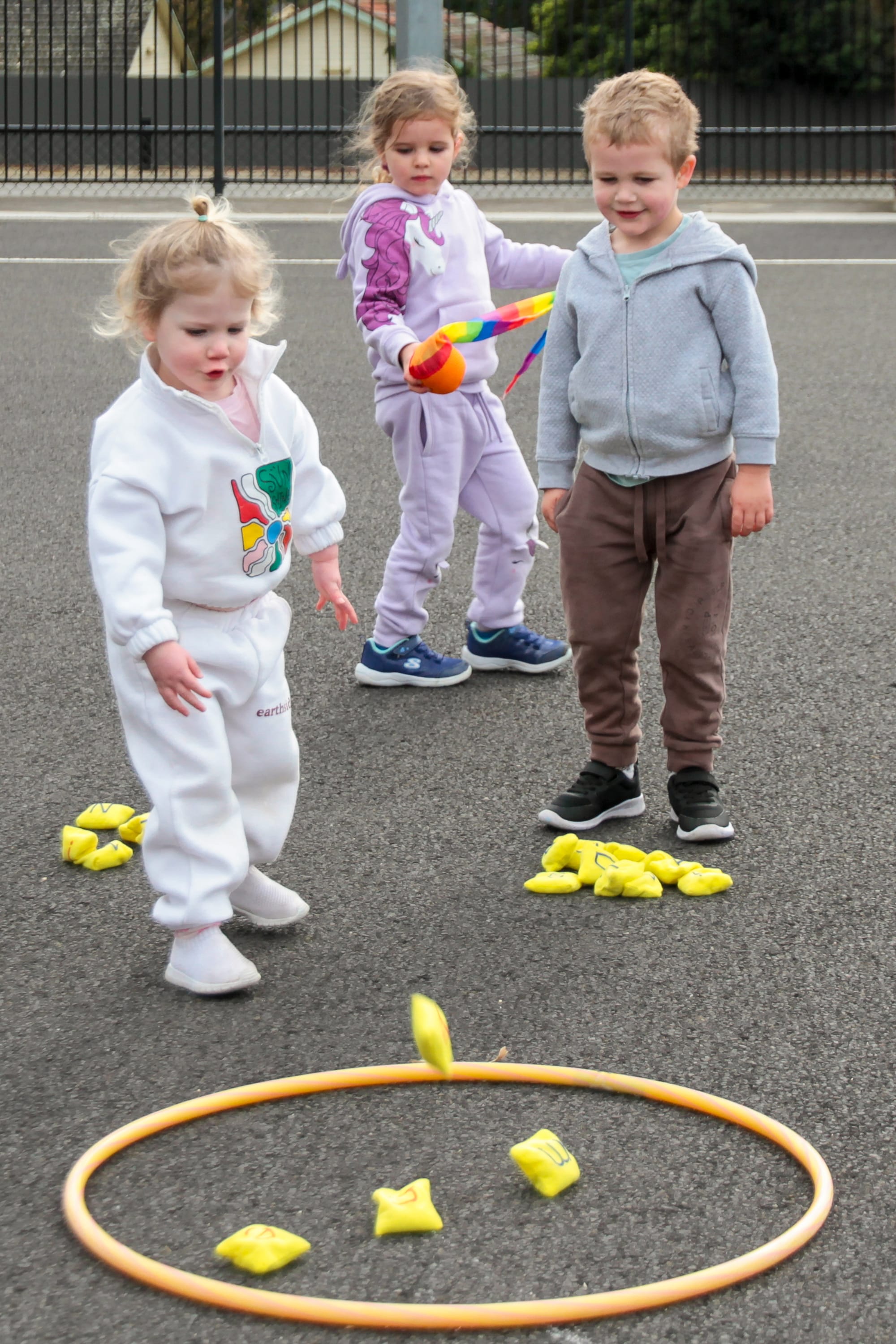 Logan Walsh, Anna Bruce and Darcy Clark are excited at the placement of their beanbags within the hoop during this Olympic event.