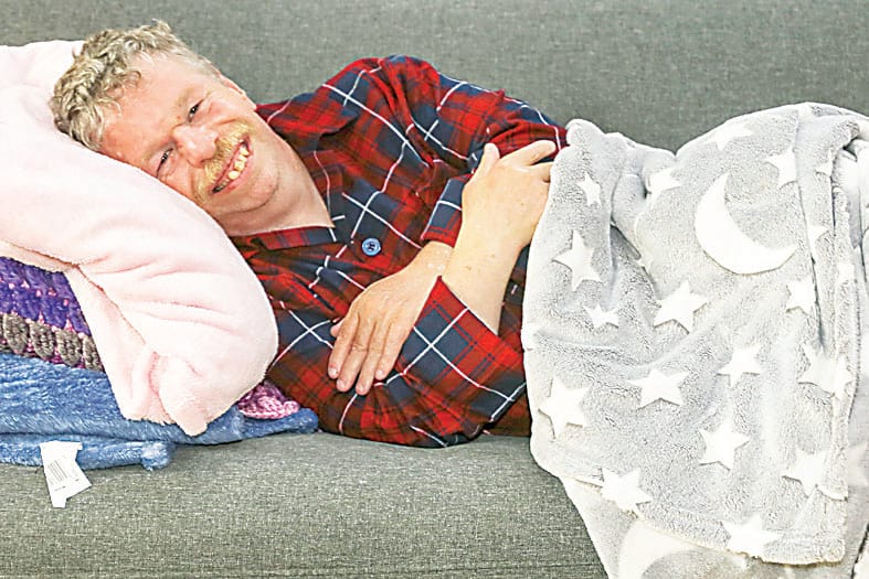 Dale snuggles in with his pillow and blanket, embracing wearing pyjamas during the day.