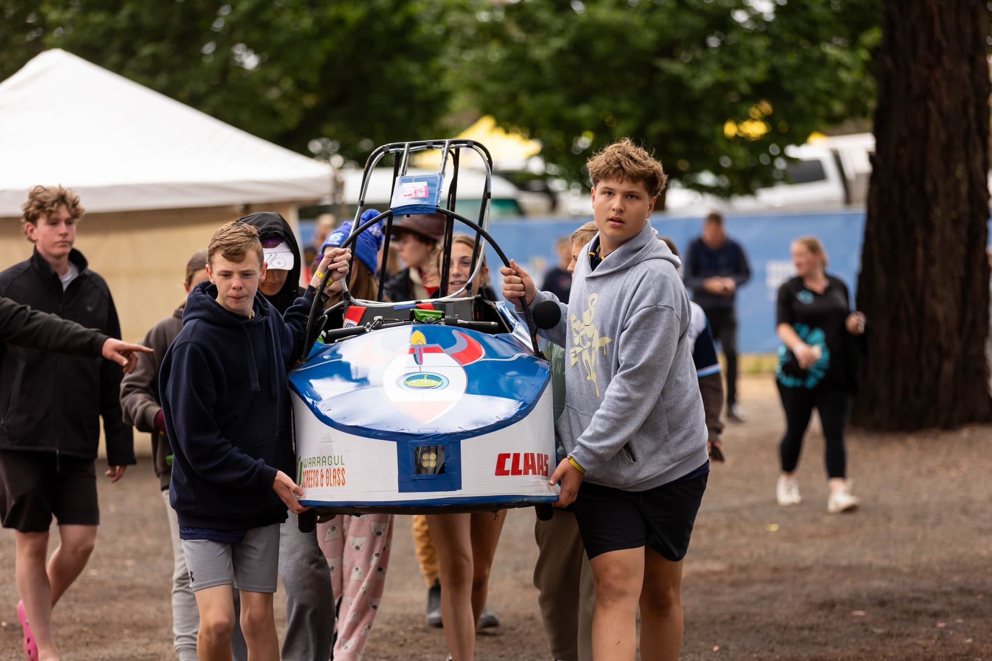 Students Spencer Bryant (left) and Ben East carry the Aliens team vehicles back to the pits for some repairs after a mishap during the annual Energy Breakthrough competition.