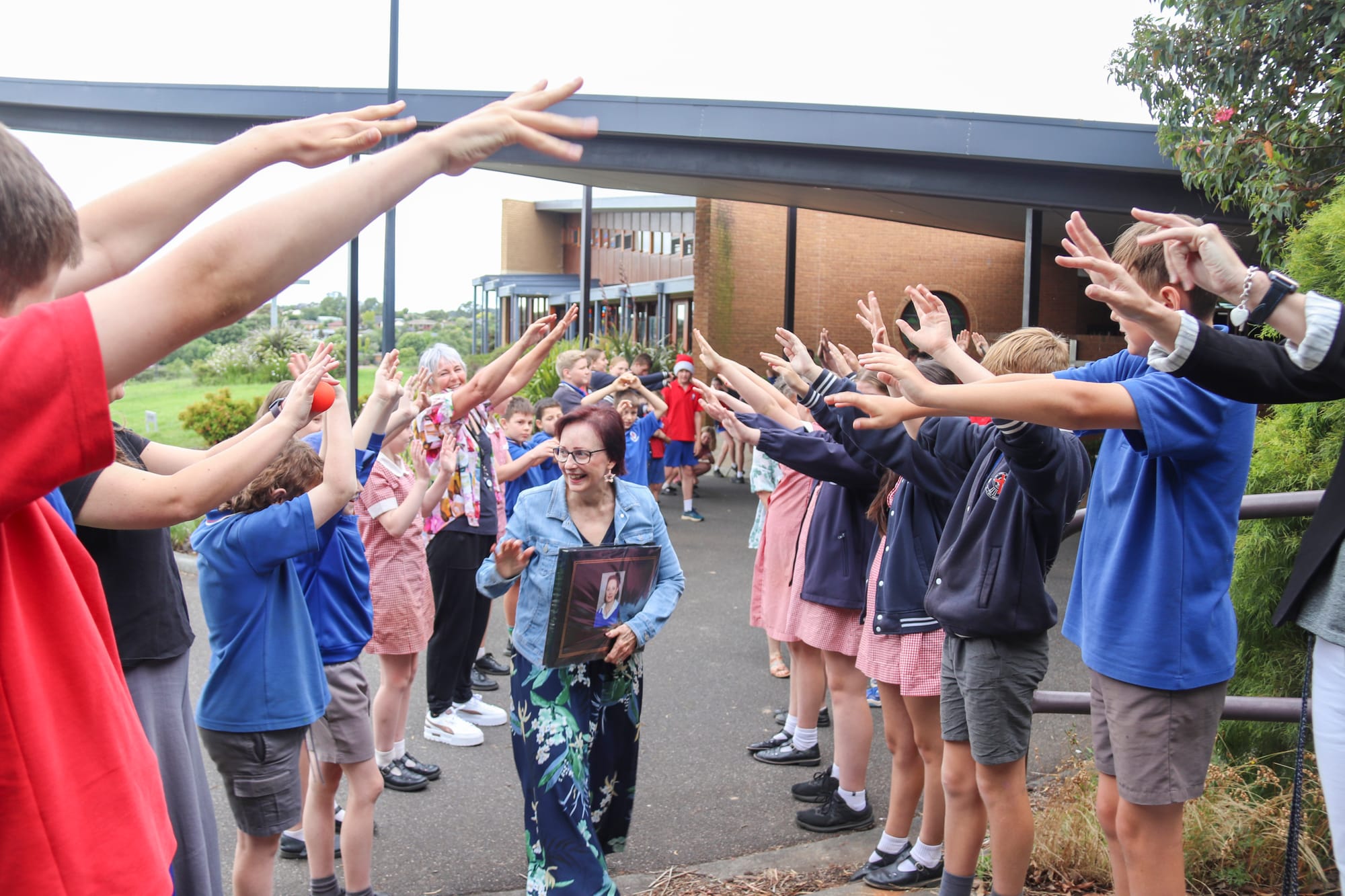 Surrounded by smiles and well wishes, Mrs Thrse Meggetto left the St Ita's end of year mass through the grade five and six guard of honour.