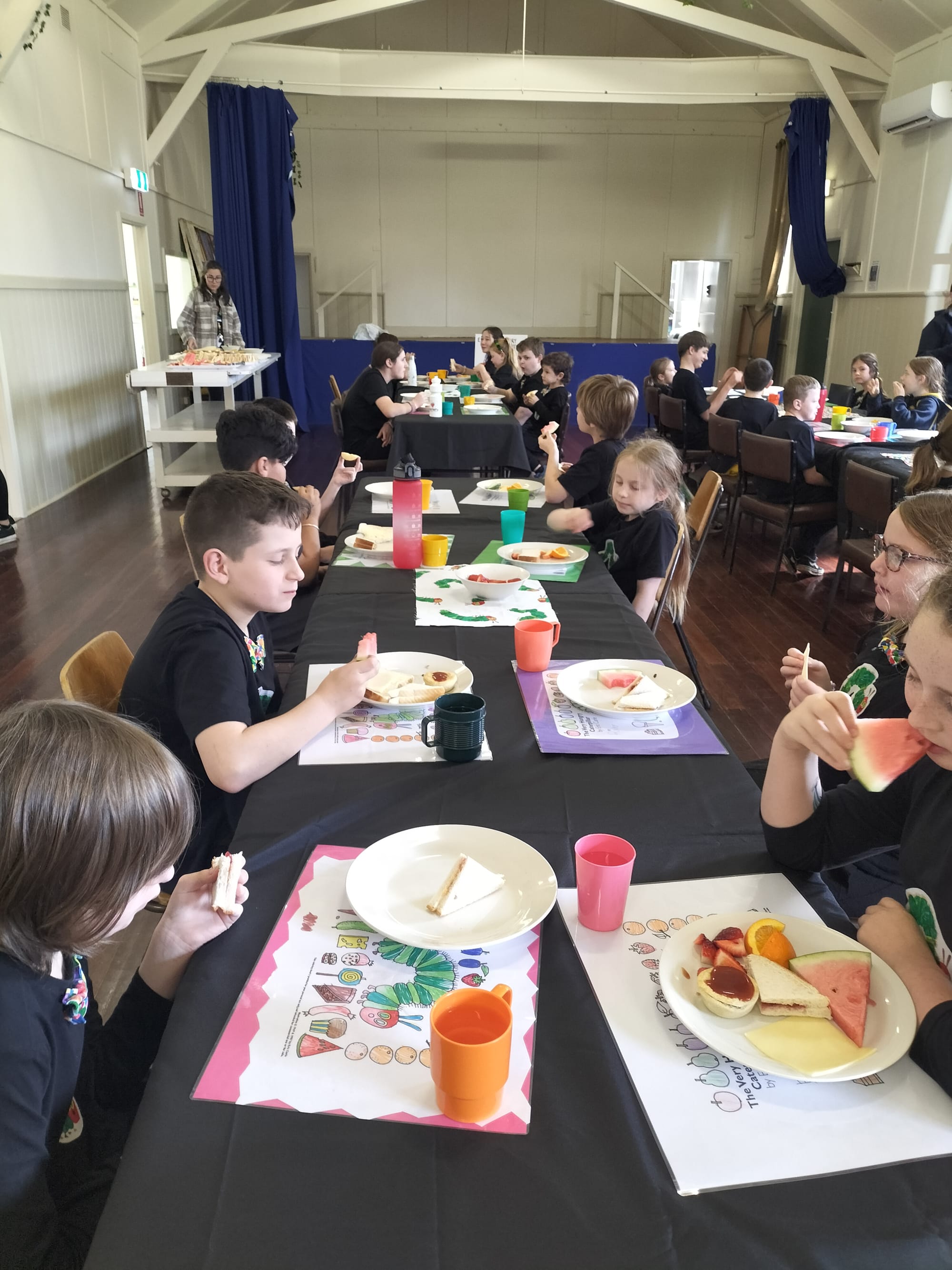 Students dig into their feast with special placemats they made for the occasion.