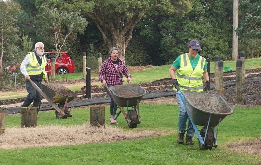 Busy wheel barrowing mulch for the native grass planting at the Indigenous Art Garden are (from the left) Darold Klindworth (community volunteer), Caroline Hammond (Latrobe Catchment Landcare Facilitator) and Fleur Craig (Warragul Rotary).