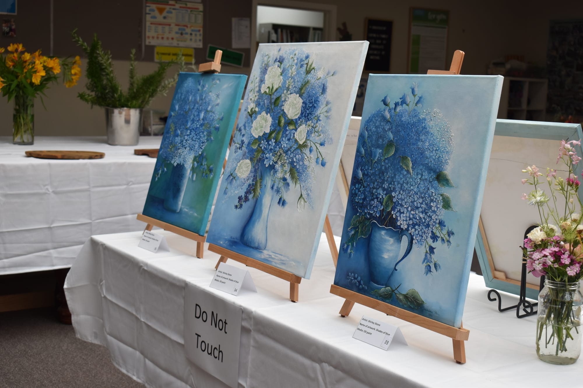 A series of still life oil paintings by Shirley Stone depicting flower arrangements.