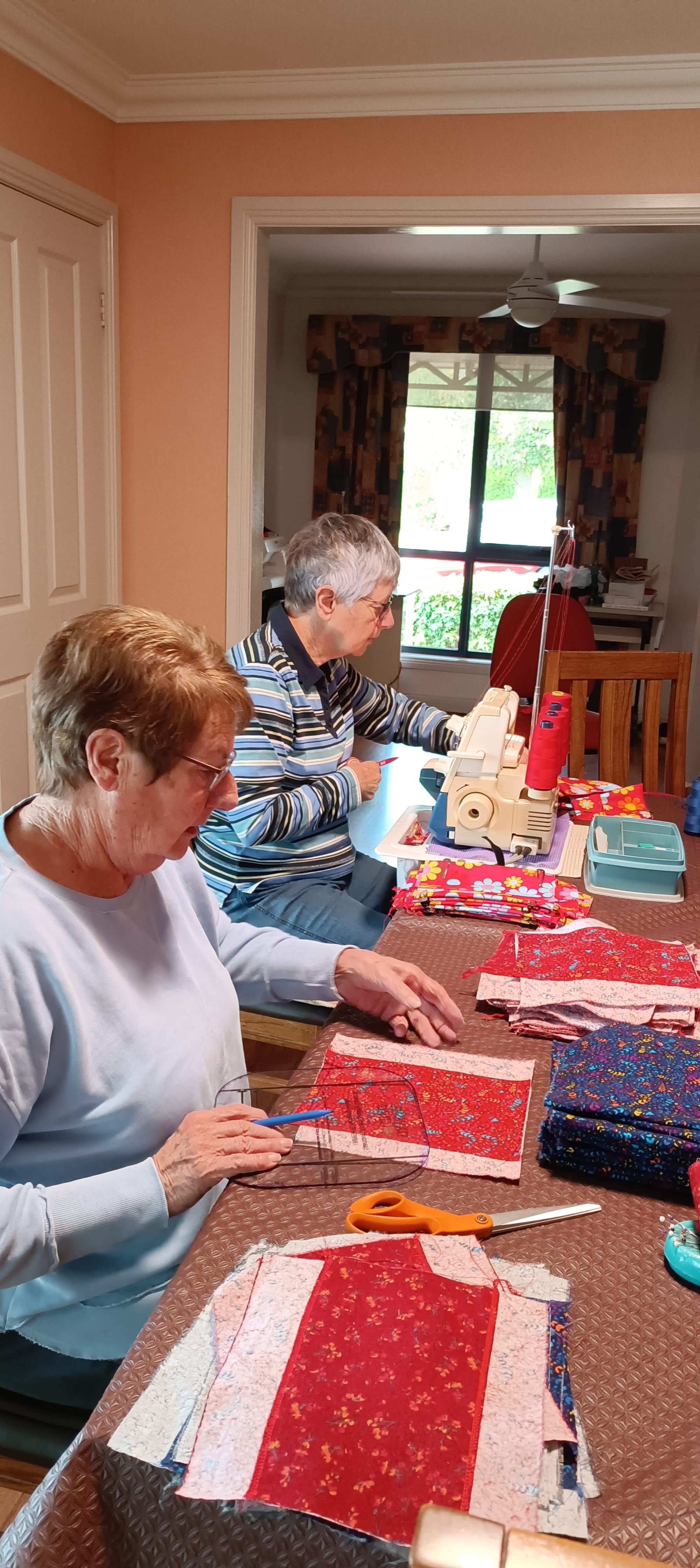 Volunteers in the Days for Girls West Gippsland team, Bronwyn Morrissey (back) and Margaret McLeish (front) working together to create reusable period products.