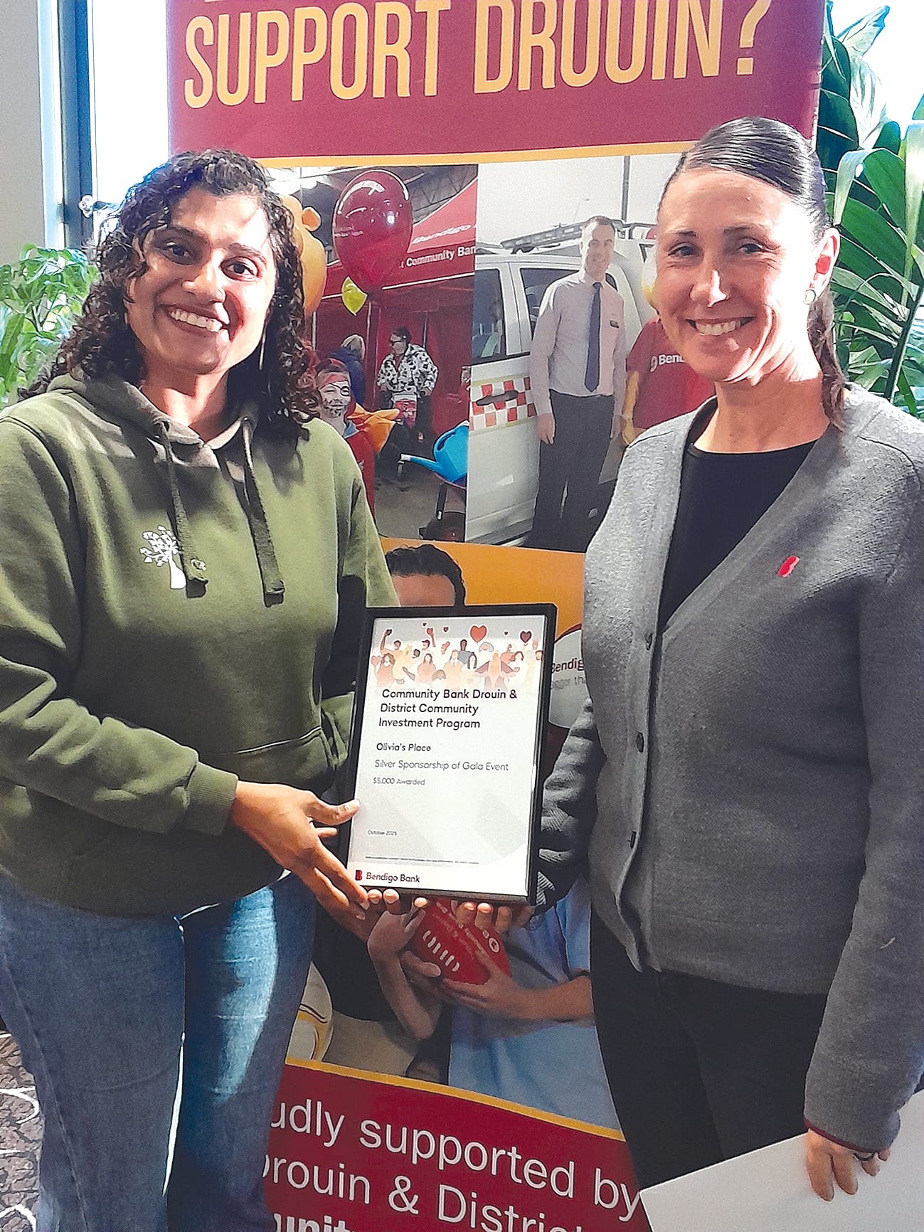 Olivia's Place general manager Pheba Daniel receives sponsorship from bank customer service officer Jade Dance.