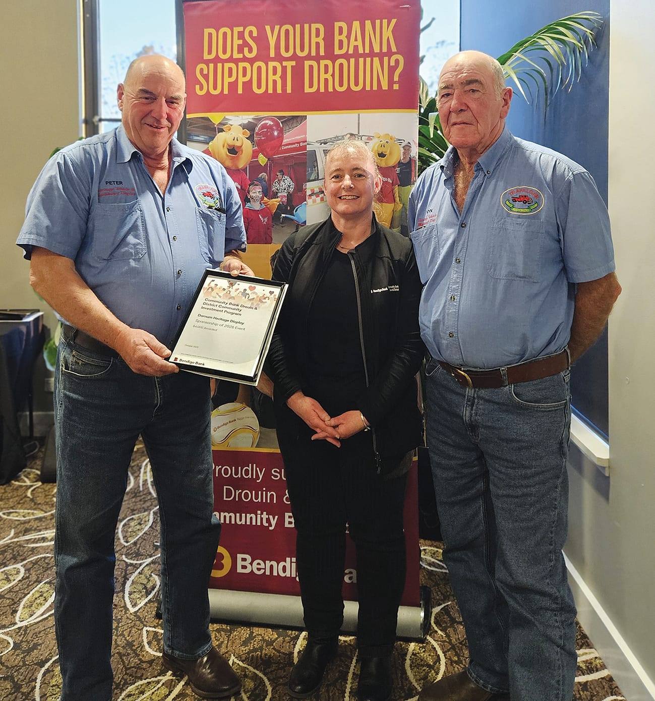 Bank administration officer Julieanne Palinkas (centre) presents funding to Darnum Heritage Display representatives Peter Farley and Vin Harris.