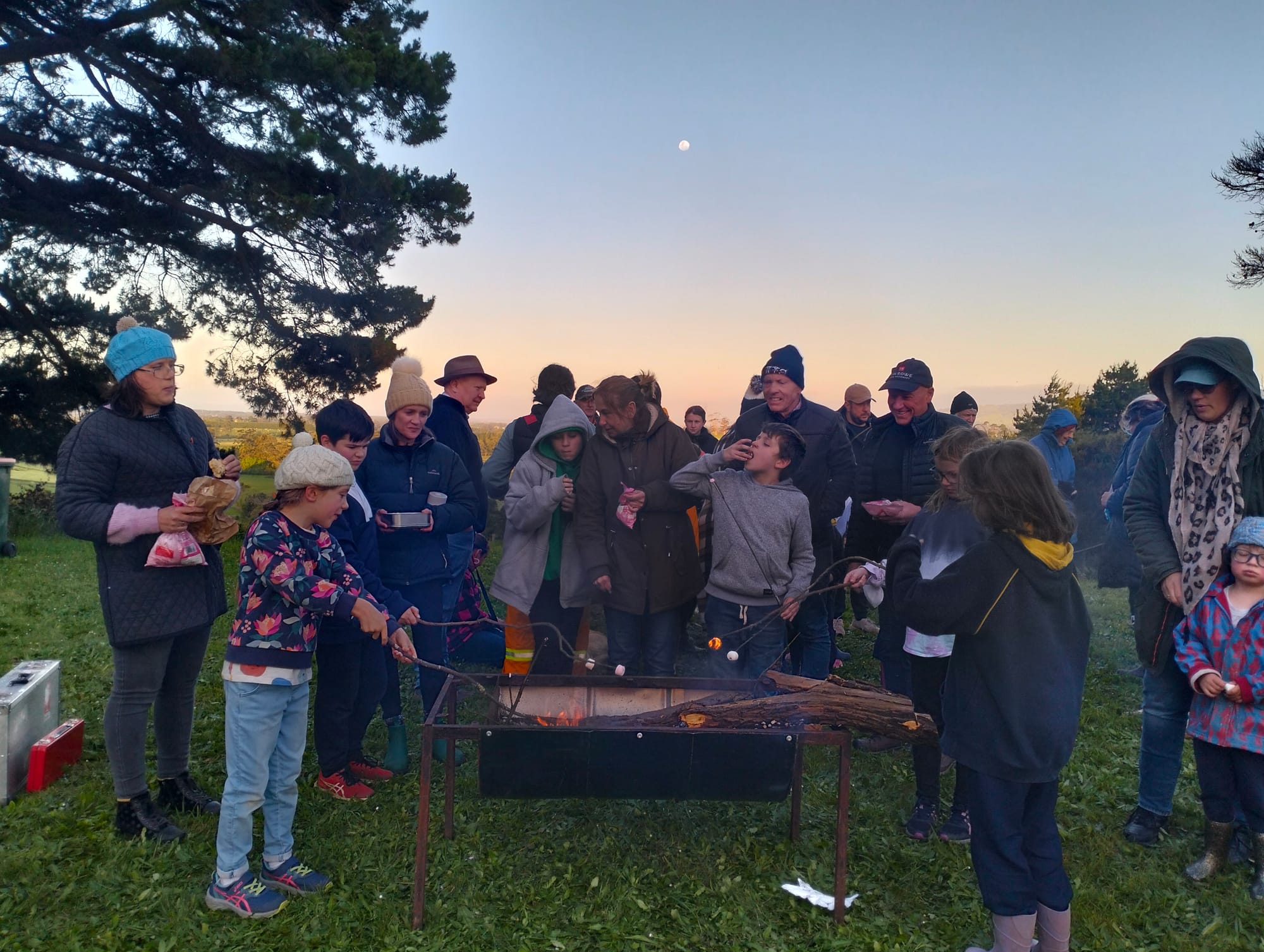 School families and local community members enjoy toasting marshmallows.