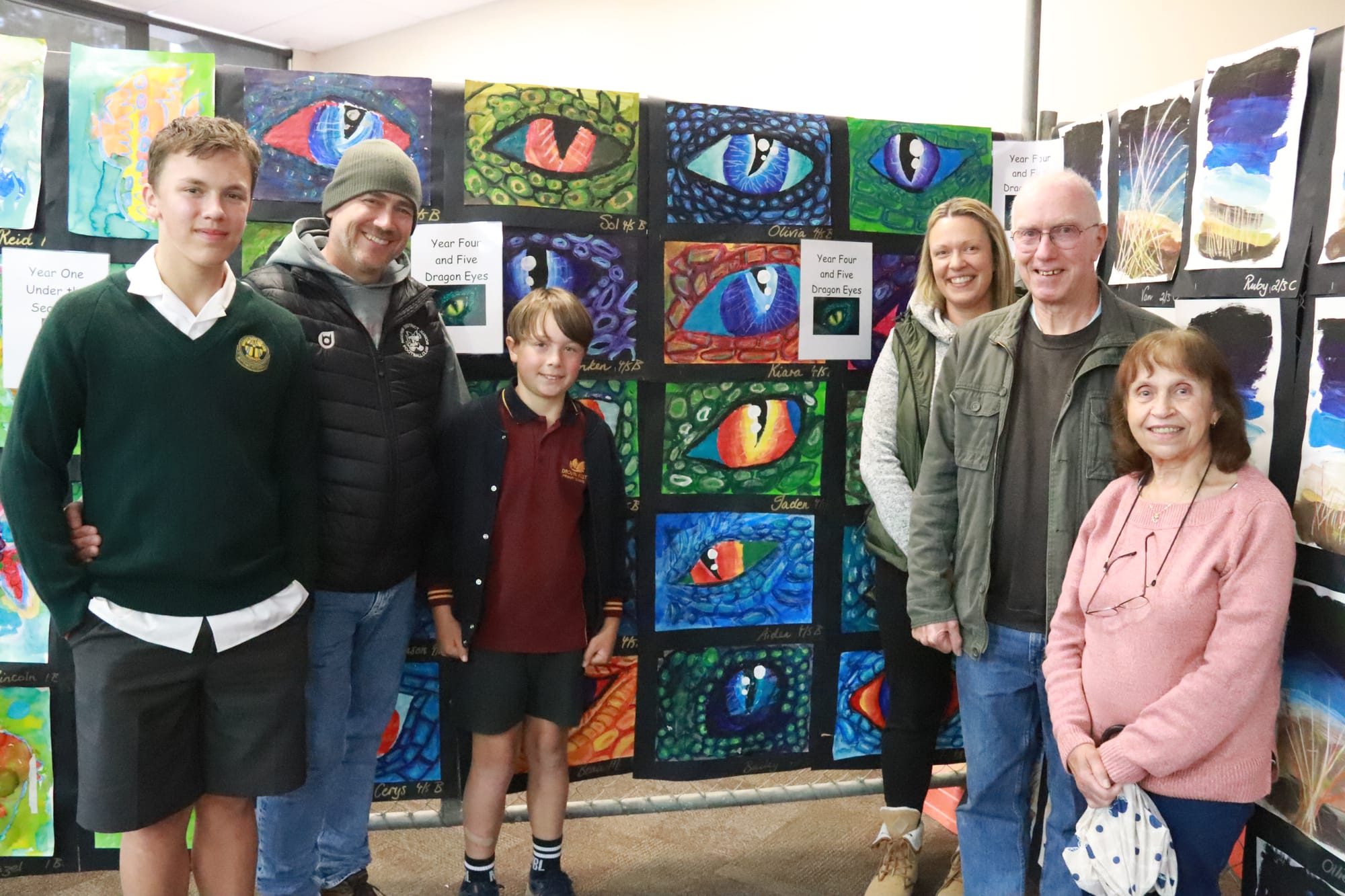 Drouin West Primary School student Jaden Cunnington shows his impressive dragon eye artwork to family members (from left) Kobe, Duane and Annette Cunnington and grandparents Harry and Anna Bettink.