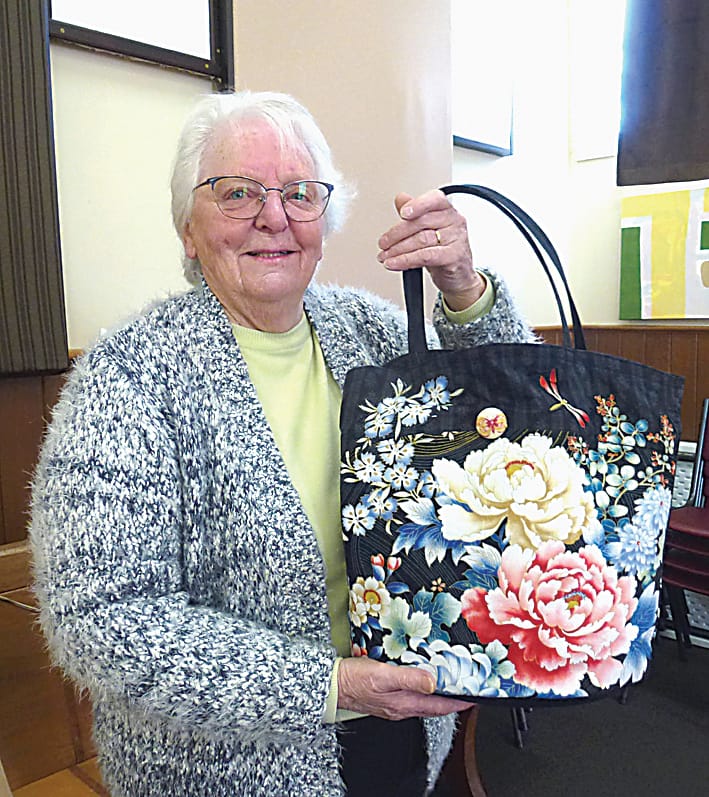 Garfield resident Margaret Dobson holds a decorative bag made by the knitting group in Garfield.