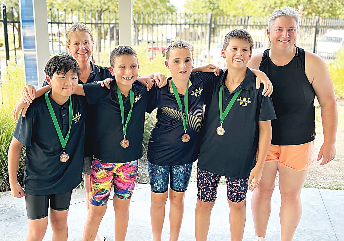 Coaches Jodie Ballantyne (left) and Michelle Chaplin congratulate the Warragul boys 10 and under freestyle relay team (from left) Hayden Ka, Lachlan Hynd, Logan Gibson and Lucas Wendt.