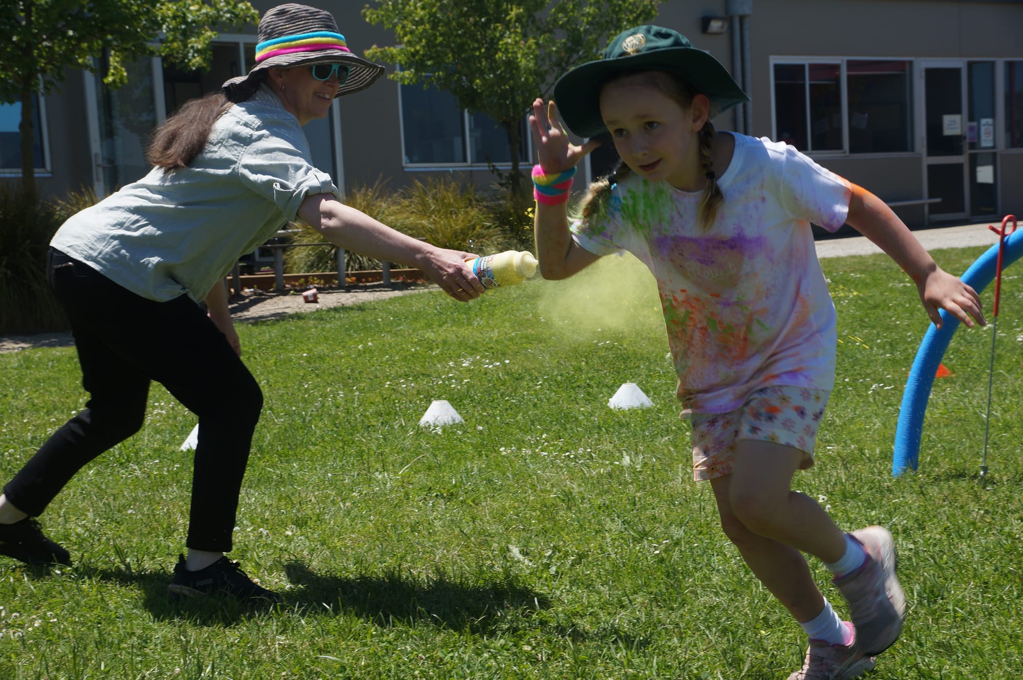 Parent Tina Barake sprays Anna during the Colour Run at St Joseph's Primary School.