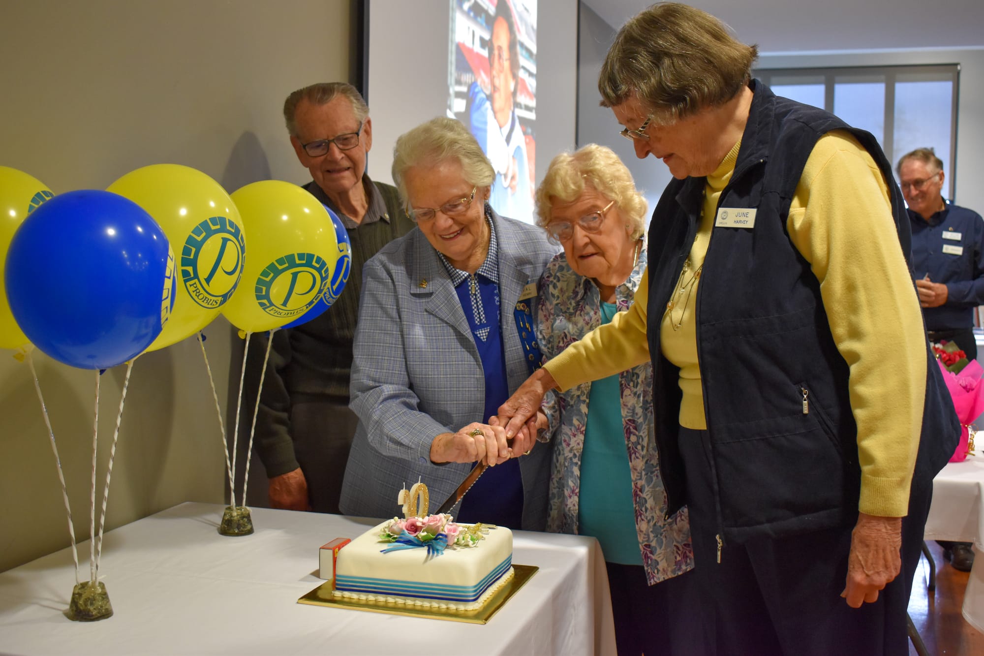 Keith Pretty, Val Henry, Beryl Burr and June Harvey cut a celebratory cake.