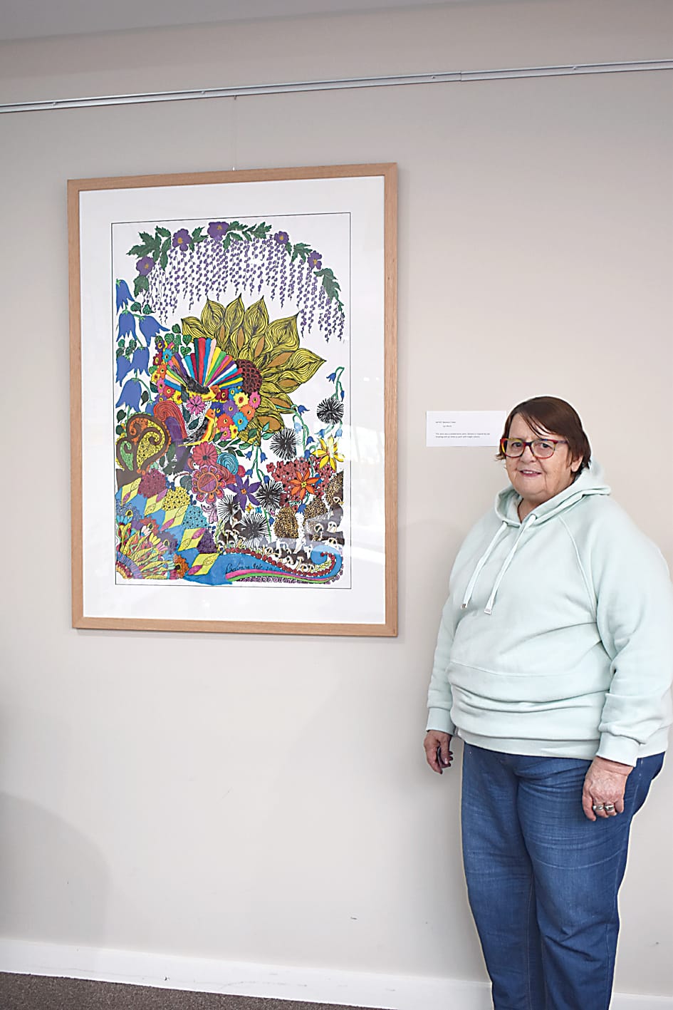 Lynne Ward stands with a painting she collaborated with Barbra Cullen on.