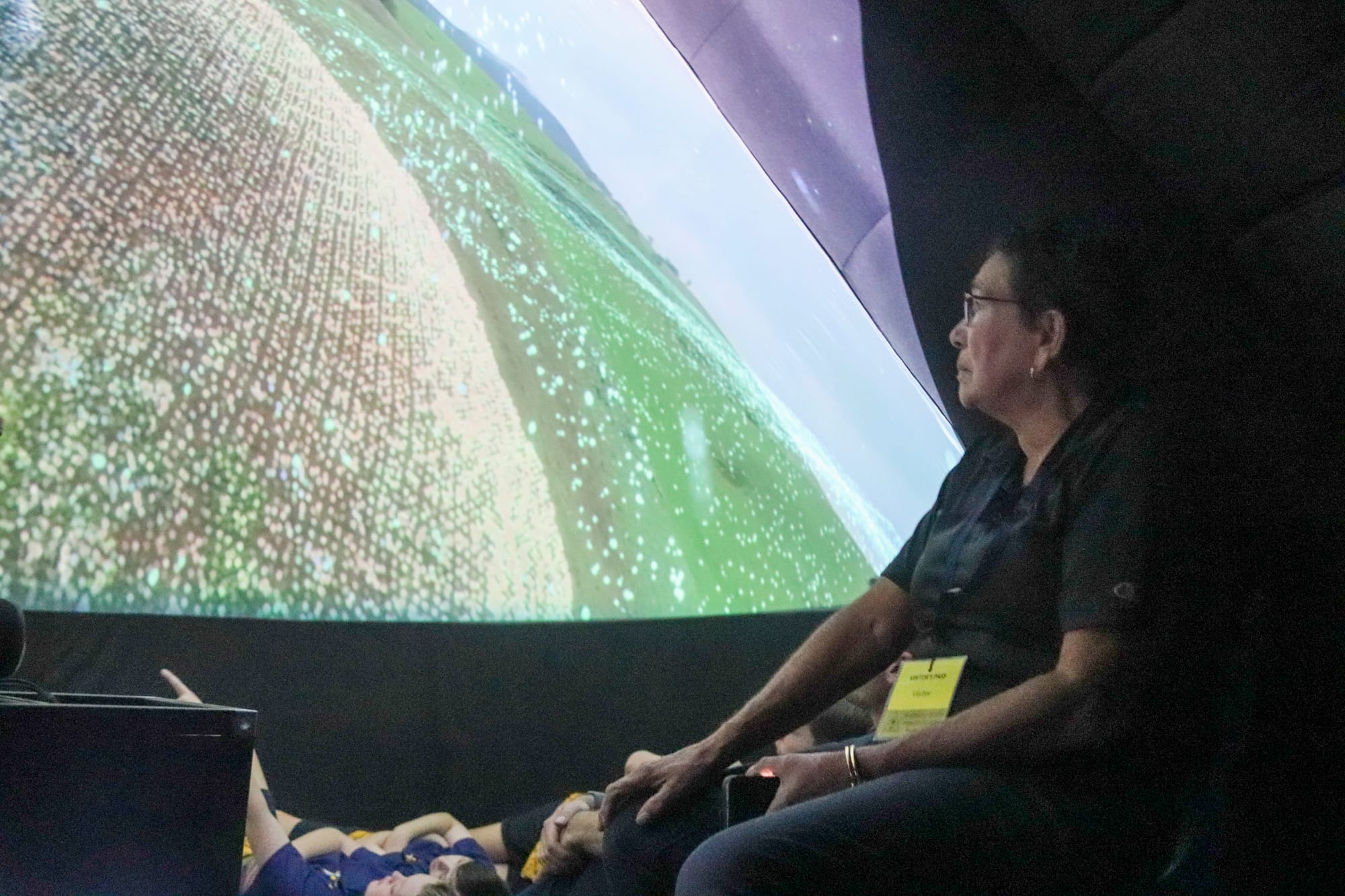 Aunty Cheryl Drayton takes in the planetarium experience alongside students from Warragul North Primary School.