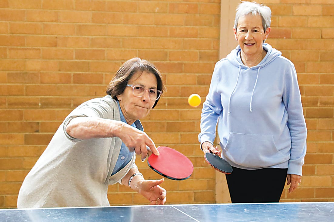 Gina Solohub is a picture of concentration on her shot as partner Rhonda Deppeler watches on. 