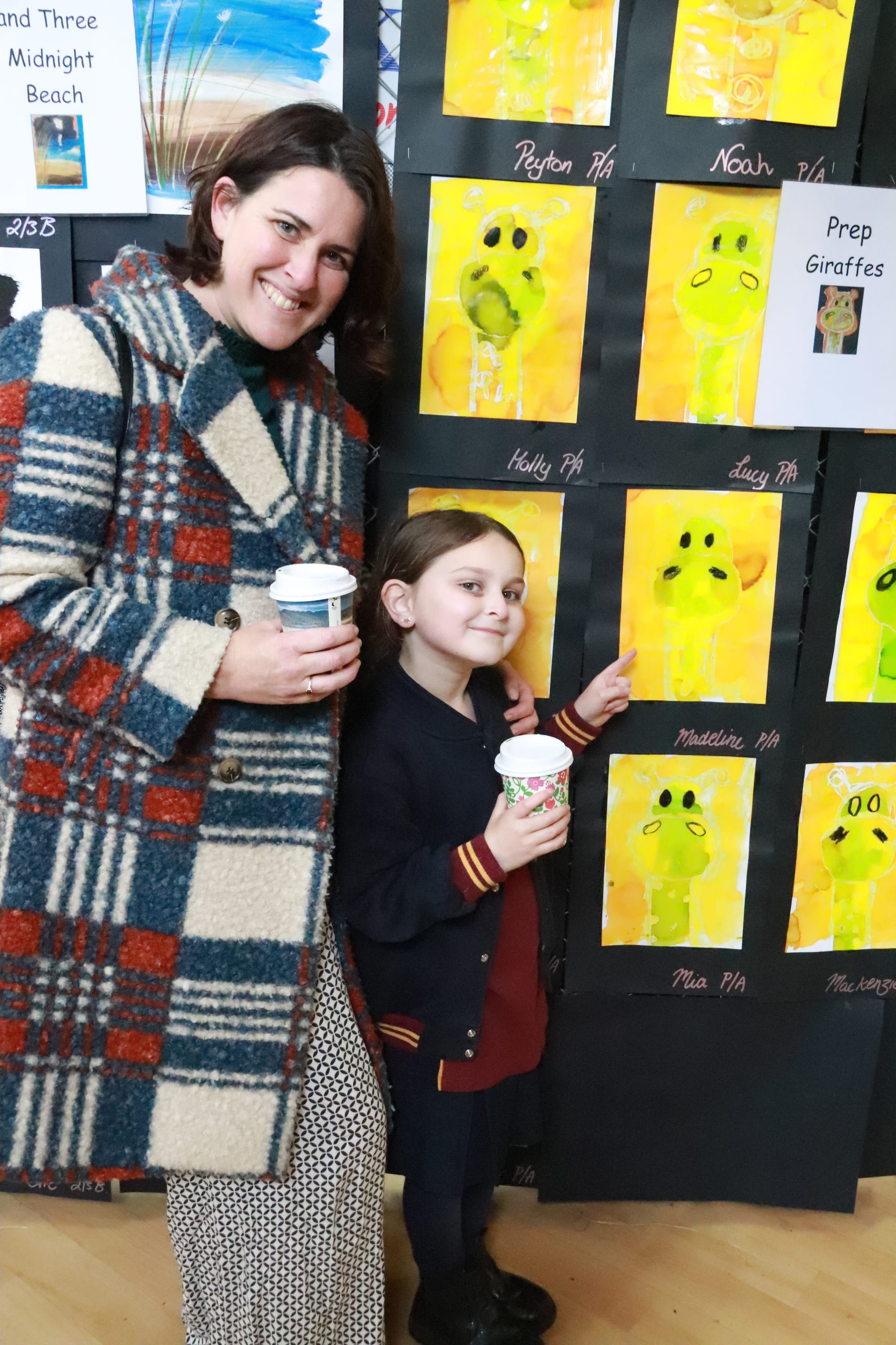 Nina Revill took Madeline Jashar stopped by the coffee van to beat the cold whilst browsing hundreds of artworks on display at Drouin West Primary School. Madeline points to one of her art pieces depicting a giraffe.