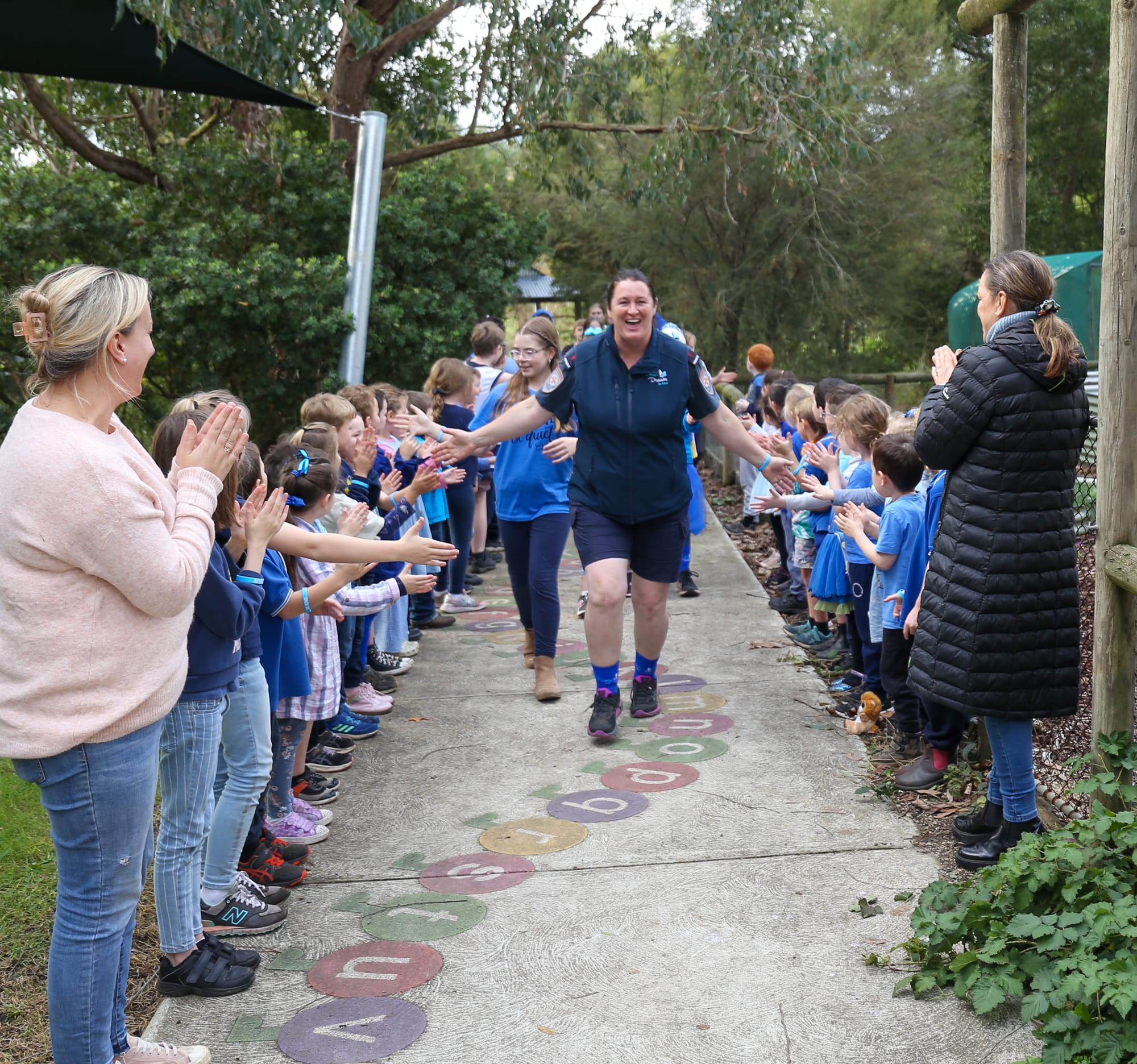 Trish Tomlin gets high-fives from Labertouche Primary students.