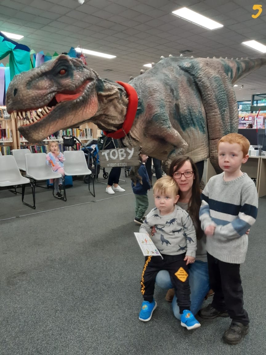 Getting up close to a life-sized dinosaur as part of Myli's school holiday program are Patrick (age two), Tameka Thomson and Bobby McNamara (age five).