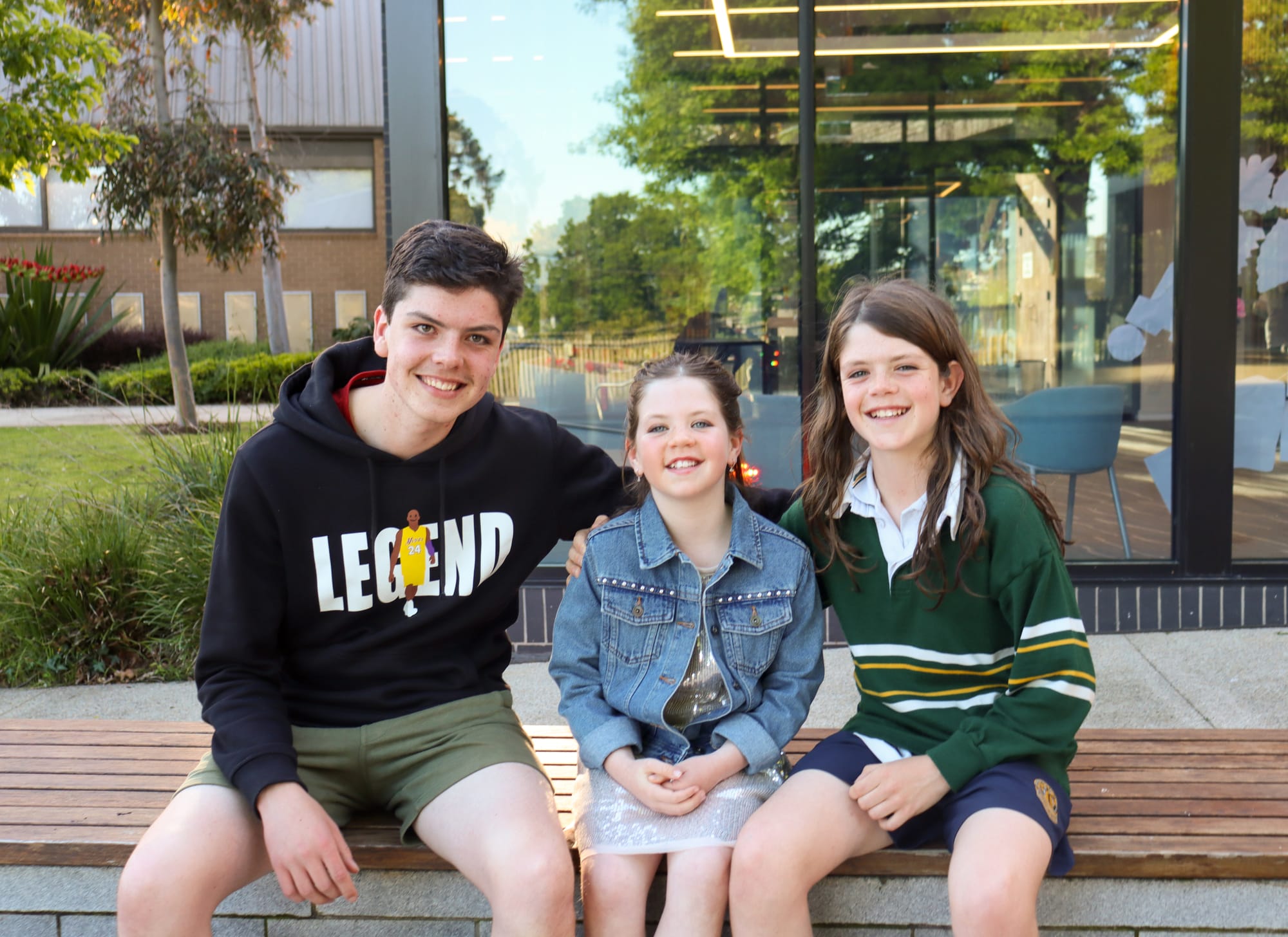 Above: Older brothers Roy (left) and Lenny Barake (right) give their little sister Eve a big hug before her performance on stage. Eve sang 