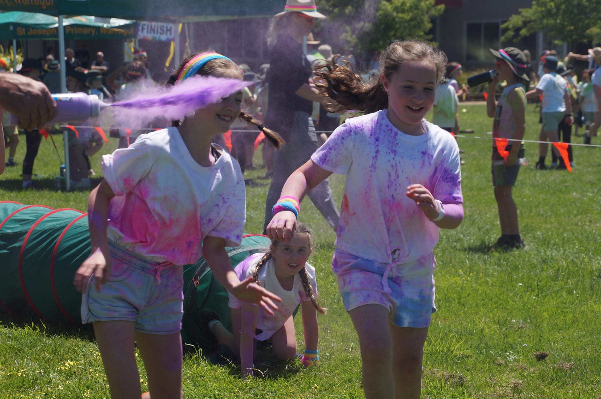 Gaining some purple at the Colour Run held at St Joseph's Primary School, Warragul are (from left) Lexi and Grace with Liv emerging from the tunnel.