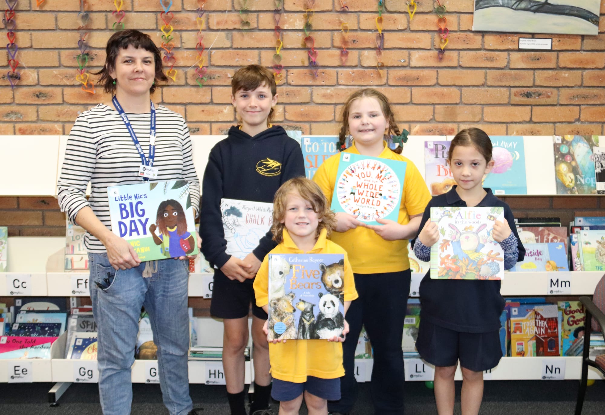 Librarian Kellie Jagoe helps Jim Thorne, Elijah Saward, Evelyn Janssen and Willow Gonzalez with their reading choices.