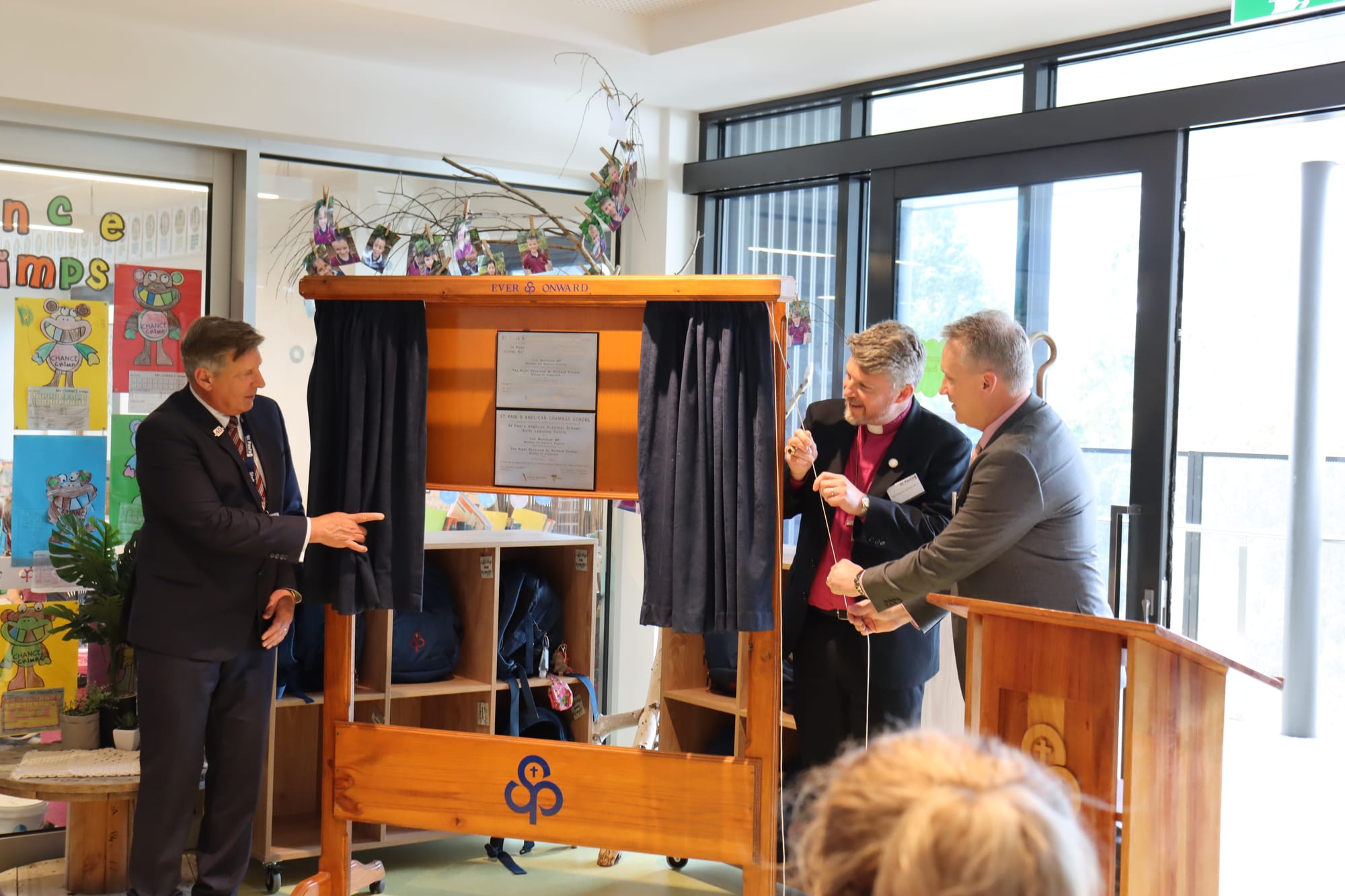 School principal Cameron Herbert, Bishop of Gippsland Richard Treloar and school board chair Darren Jennings unveil the plaque for the new building.